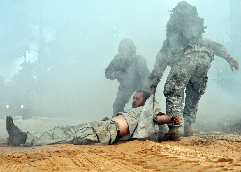 Sgt. Sean Lewis and Spc. Ian Jones, 6th Ranger Training Battalion medics, drag a simulated car accident victim away from the crash site to safety Oct. 1 during the 6th RTB's annual mass casualty exercise.  The exercise was to examine how effective the battalion responds as a group and how well it communicates and works with outside emergency agencies in the event of a catastrophe on Eglin's range.  (U.S. Air Force photo/Airman Anthony Jennings.)