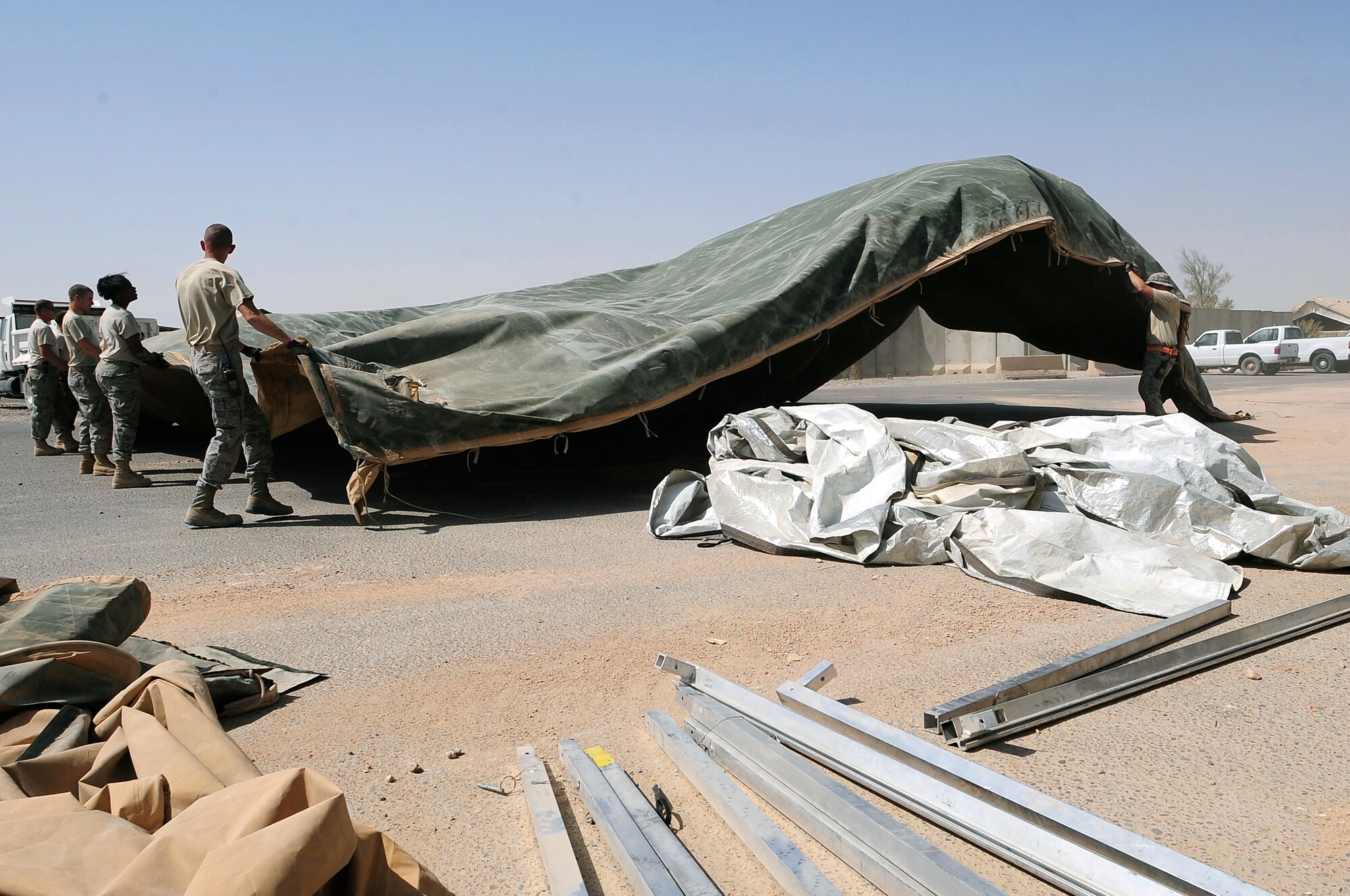 Members of the 407th Expeditionary Civil Engineer Squadron take down a tent structure Sept. 30, 2009, at Ali Base, Iraq. Squadron members are downsizing and consolidating material and equipment to send to U.S. warfighters in Afghanistan. (U.S. Air Force photo/Senior Airman Tony R. Ritter) 