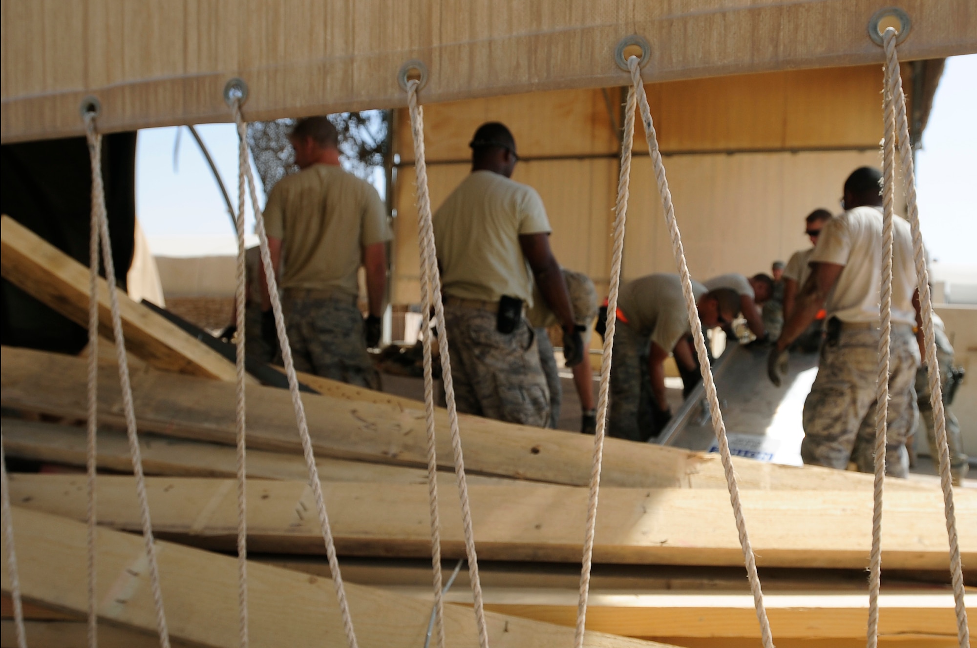 Members of the 407th Expeditionary Civil Engineer Squadron take down a tent structure Sept. 30, 2009, at Ali Base, Iraq. Squadron members are downsizing and consolidating material and equipment to send to U.S. warfighters in Afghanistan. (U.S. Air Force photo/Senior Airman Tony R. Ritter) 