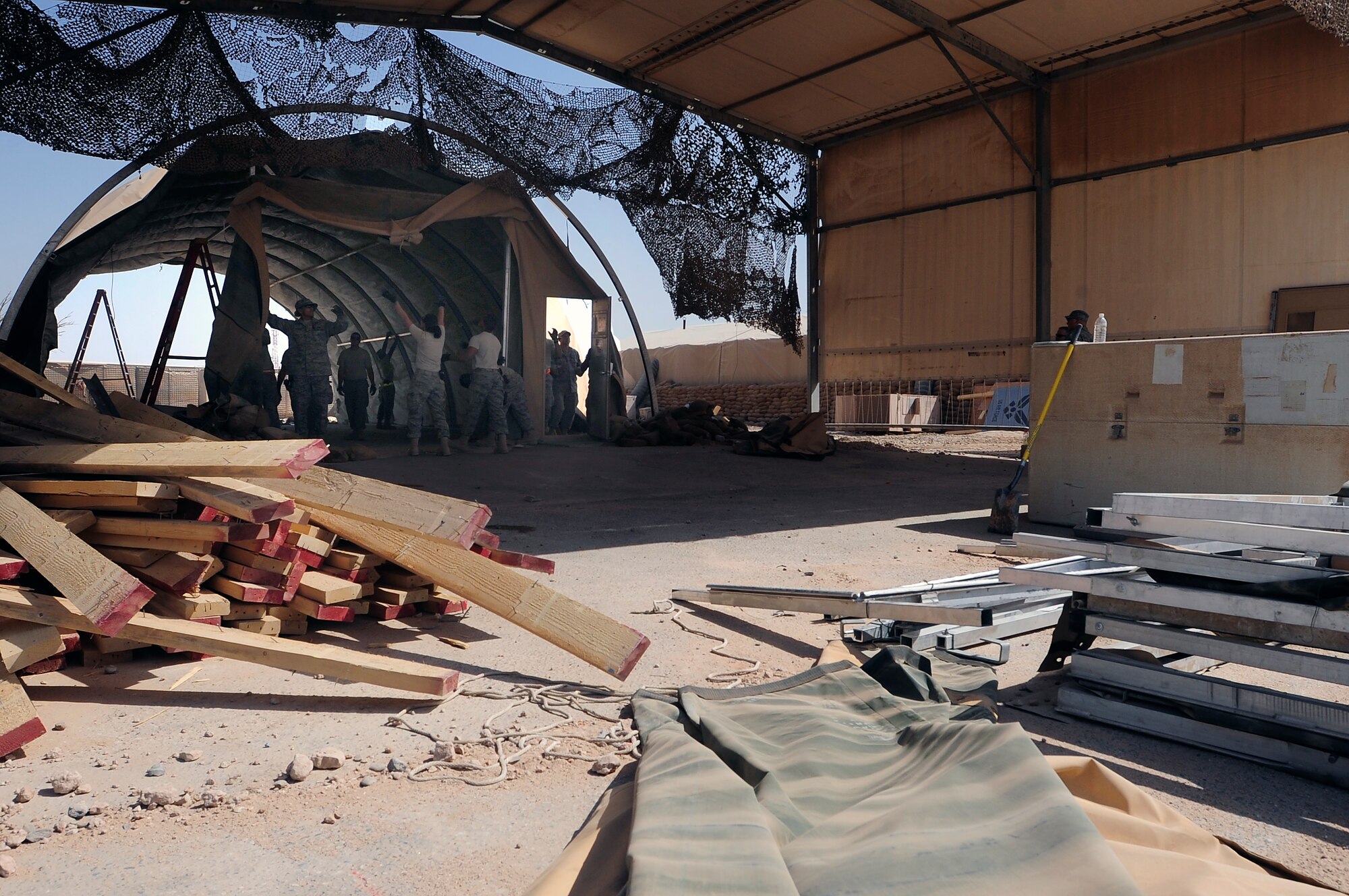 Members of the 407th Expeditionary Civil Engineer Squadron take down a tent structure Sept. 30, 2009, at Ali Base, Iraq. Squadron members are downsizing and consolidating material and equipment to send to U.S. warfighters in Afghanistan. (U.S. Air Force photo/Senior Airman Tony R. Ritter) 