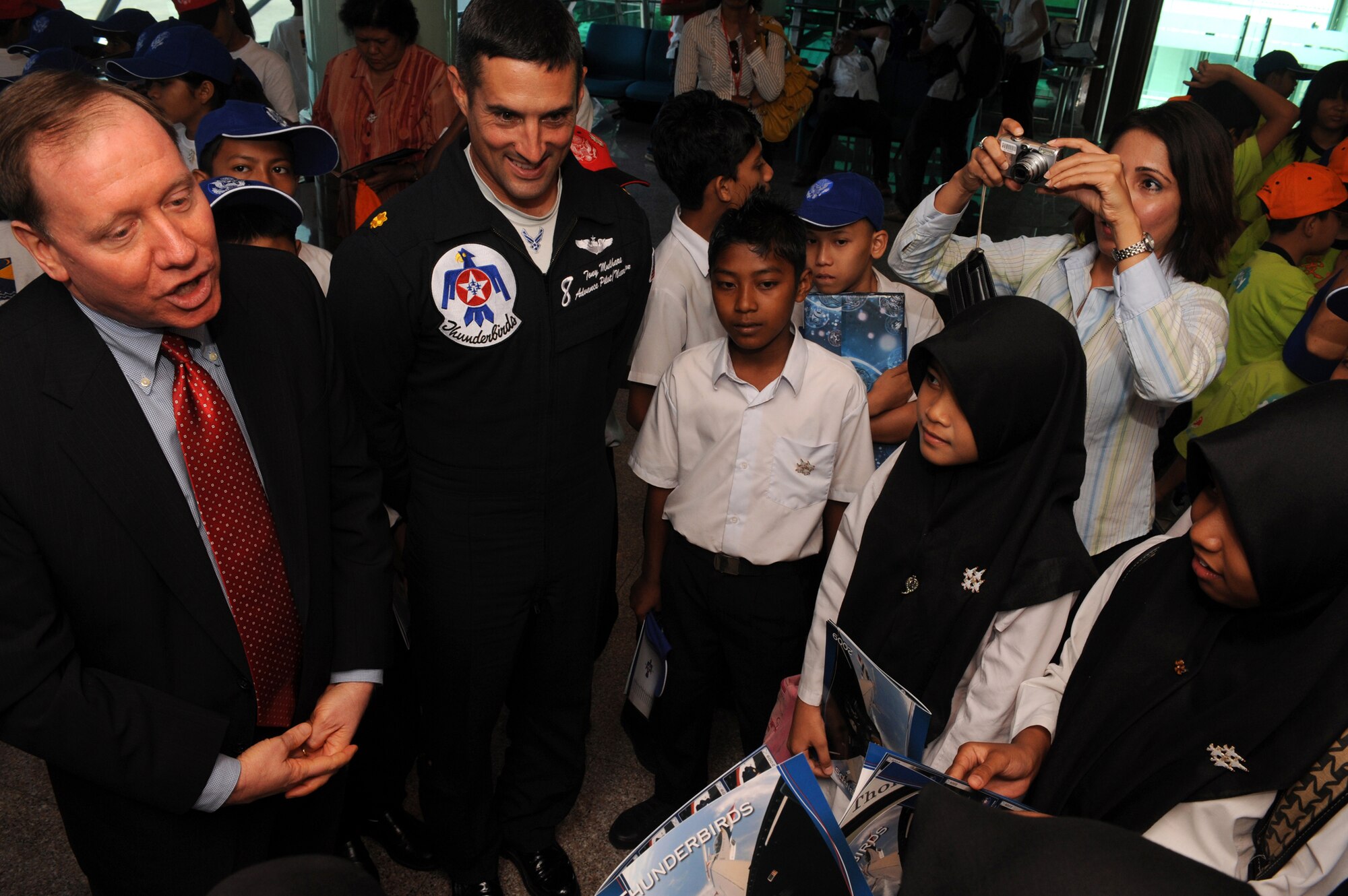 U.S. Ambassador James Keith (left) and Maj. Tony Mulhare, Thunderbird #8, speak with local Malaysian children, Oct. 1 during an air show in Kuala Lumpur, Malaysia. The Thunderbirds' tour of the Pacific aids in fostering friendships with U.S. allies, which helps to promote security and stability in the region. (U.S. Air Force photo/Staff Sgt. Kristi Macahdo)