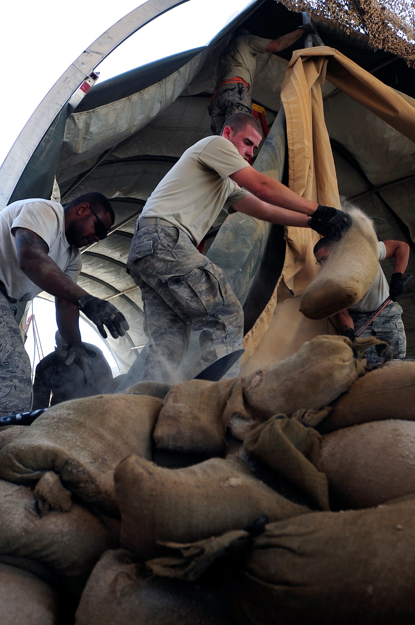 Members of the 407th Expeditionary Civil Engineer Squadron take down a tent structure Sept. 30, 2009, at Ali Base, Iraq. Squadron members are downsizing and consolidating material and equipment to send to U.S. warfighters in Afghanistan. (U.S. Air Force photo/Senior Airman Tony R. Ritter) 