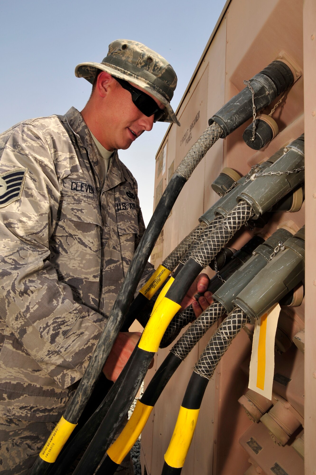 SOUTHWEST ASIA -Tech. Sgt. Joshua Cleven, 380th Expeditionary Civil Engineer Squadron, tightens a connector plug on a power distribution system here Oct. 5, 2009. Sergeant Cleven and 12 other Airmen worked around the clock to bring electricity to 22 tents housing more than 200 Soldiers. Sergeant Cleven is deployed from Travis Air Force Base, Calif., and grew up in Hampton, Va. (U.S. Air Force photo/Tech. Sgt. Charles Larkin Sr)