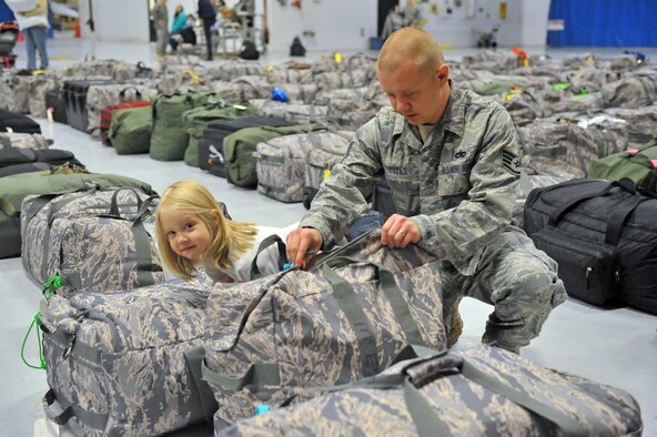 SHAW AIR FORCE BASE, S.C. -- Staff Sgt. Matthew Estes, 20th Equipment Maintenance Squadron, checks his bags with his daughter Sarah, 4, Oct. 5. Sergeant Estes will be deploying to Afghanistan. (U.S. Air Force photo/Senior Airman Kathrine McDowell)