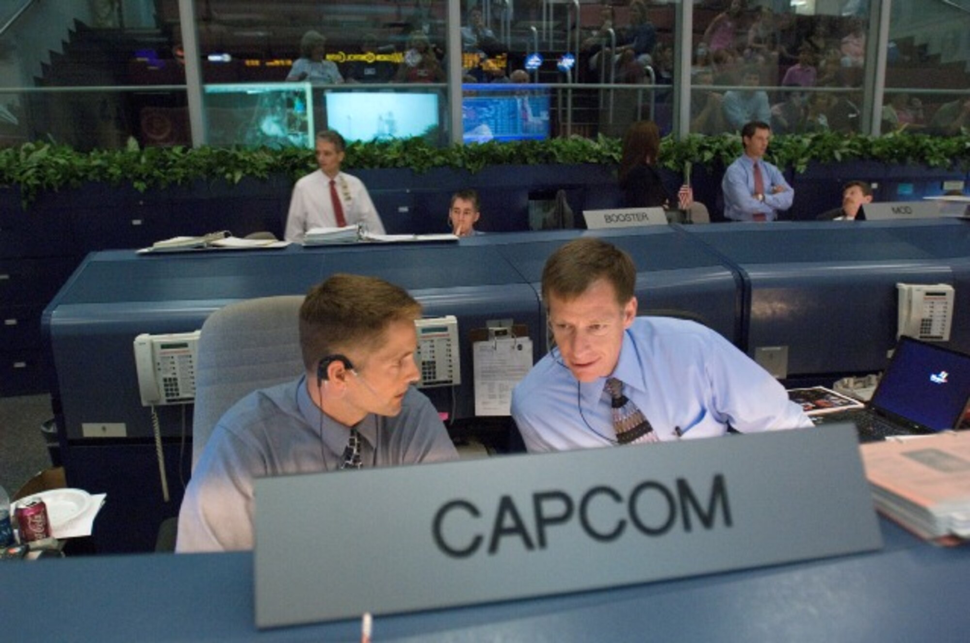 Astronauts Christopher Ferguson (right), a Navy captain, and James Dutton Jr., a lieutenant colonel in the Air Force, sit at the Spacecraft Communicators console in the space shuttle flight operations control room of the Johnson Space Center in Houston, Texas, Aug. 8, 2007. The astronauts were monitoring a launch of the Space Shuttle Endeavour several hundred miles away in Florida. (Courtesy photo)