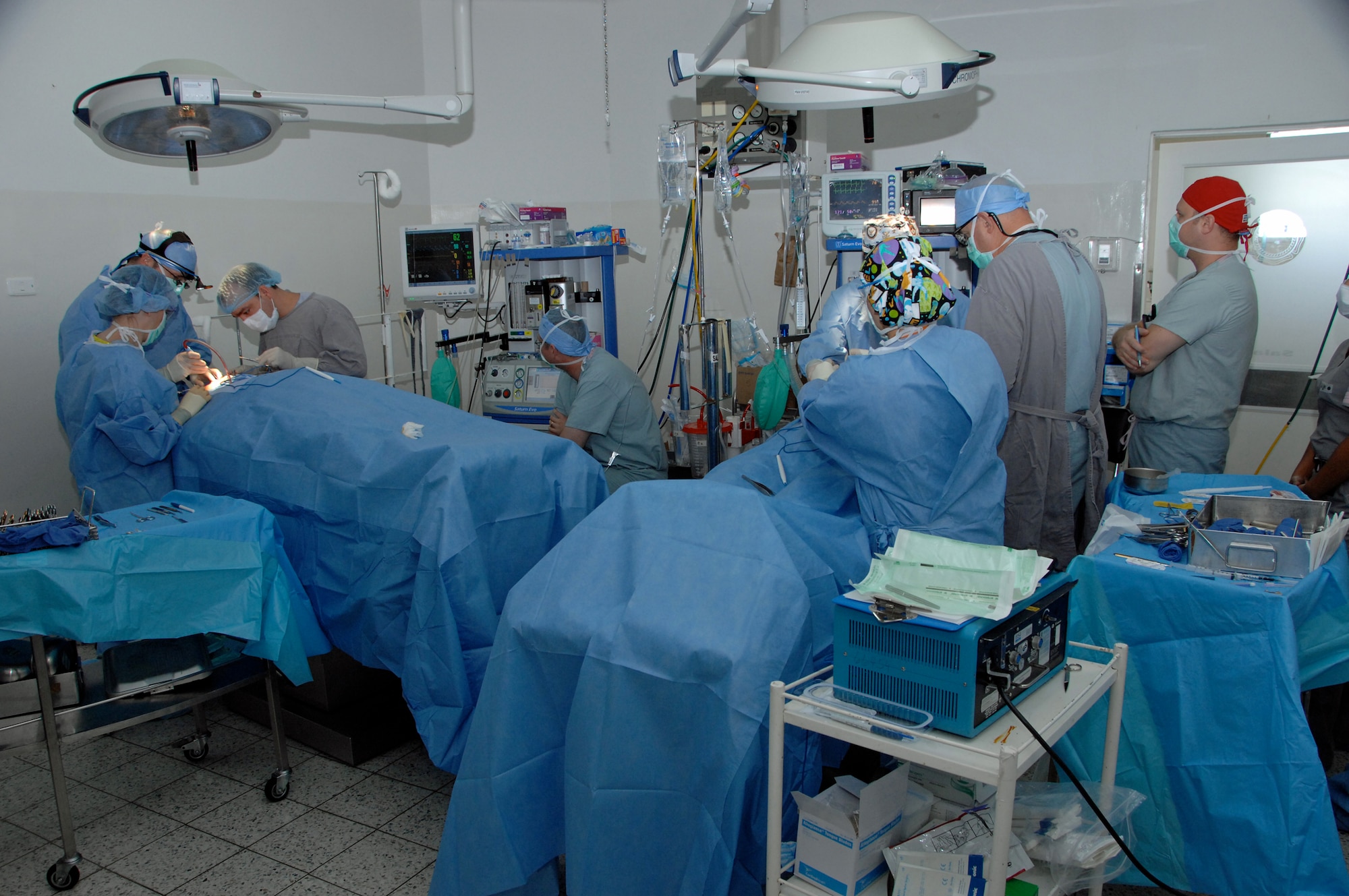 The operating room set up during MEDRETE 2009 medical readiness training exercise in Cartagena, Columbia, enabled joint teams to perform two plastic surgeries simultaneously.  Dr. Matthew Talarczyk of Wright-Patterson Air Force Base, Ohio, led one team (left), and Dr. Charles Hardin of Lackland Air Force Base, Texas, led the other, assisted by Mauricio Bolivar, a plastic surgeon with the Columbian Navy.  (U.S. Army photo/Miguel A. Negron)
