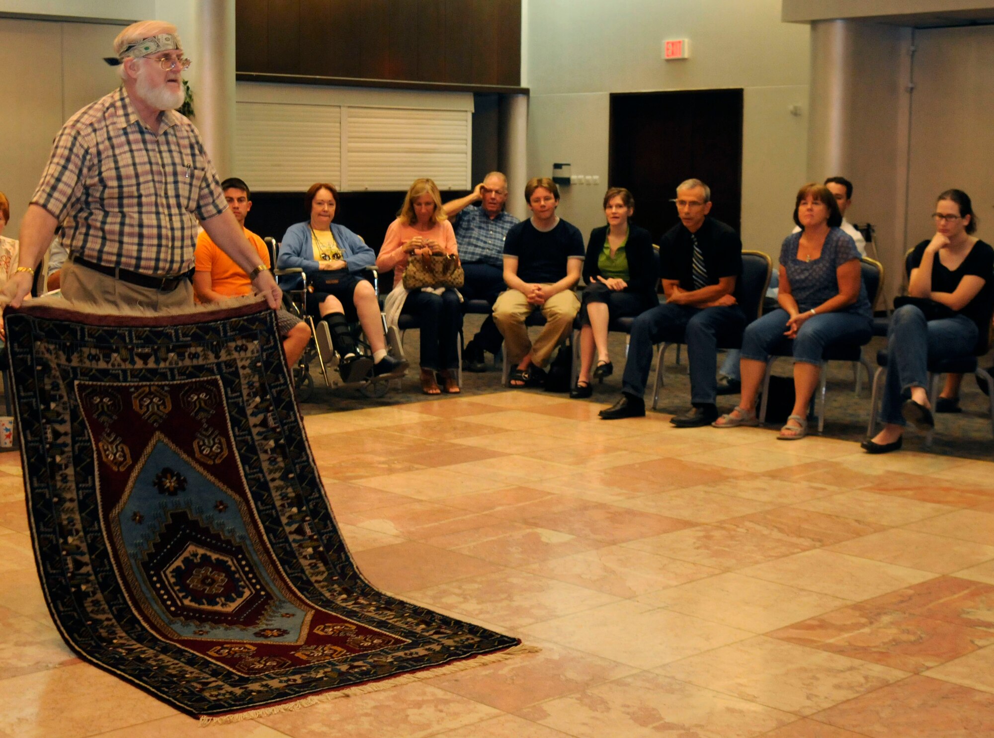 Fred Moore, 39th Contracting Squadron, shows Incirlik members a wool carpet originating from Central Turkey during the handmade carpet orientation at the Club Complex Friday, Oct. 2, 2009, at Incirlik Air Base, Turkey. The orientation was put on by Mr. Moore and his wife, Carol, who have traveled all over Turkey and have been collecting carpet knowledge for over 25 years. The orientation introduced structure, material, regions of origin and characteristic qualities of carpets.  (U.S. Air Force photo/Airman 1st Class Amber Ashcraft)