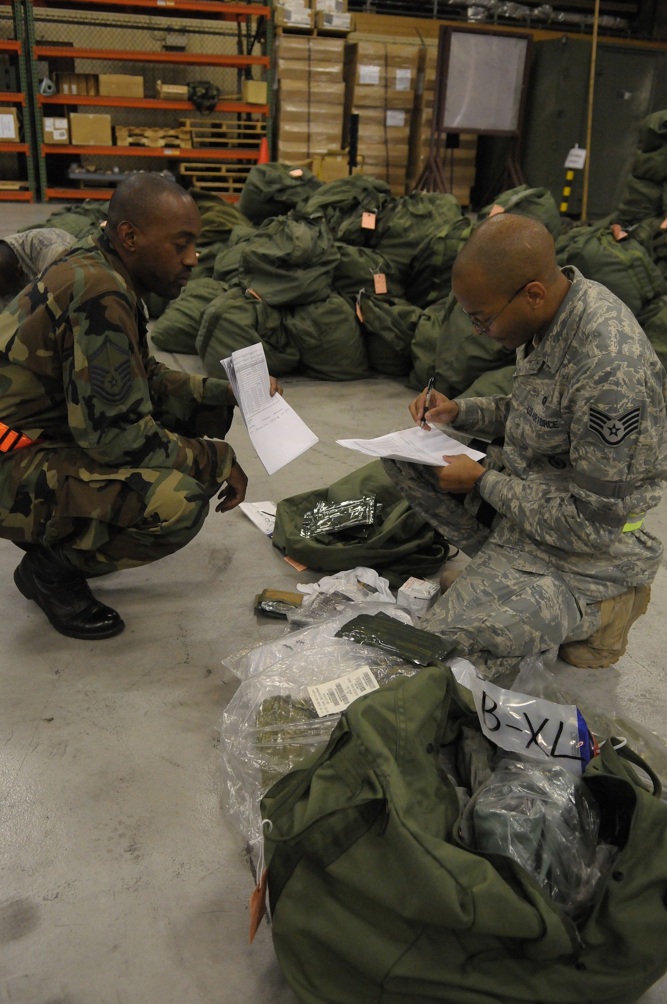 YOKOTA AIR BASE, Japan -- Staff Sgt. Joseph Blake, 374th Security Forces Squadron, (right) inspects his individual protective equipment with Master Sgt. Lynval McKenzie, 374th Logistics Readiness Squadron, during Beverly-Bearcat 09-05, an operational readiness inspection conducted by the Pacific Air Forces Inspector General. (U.S. Air Force photo/Airman 1st Class Michael Dillon)