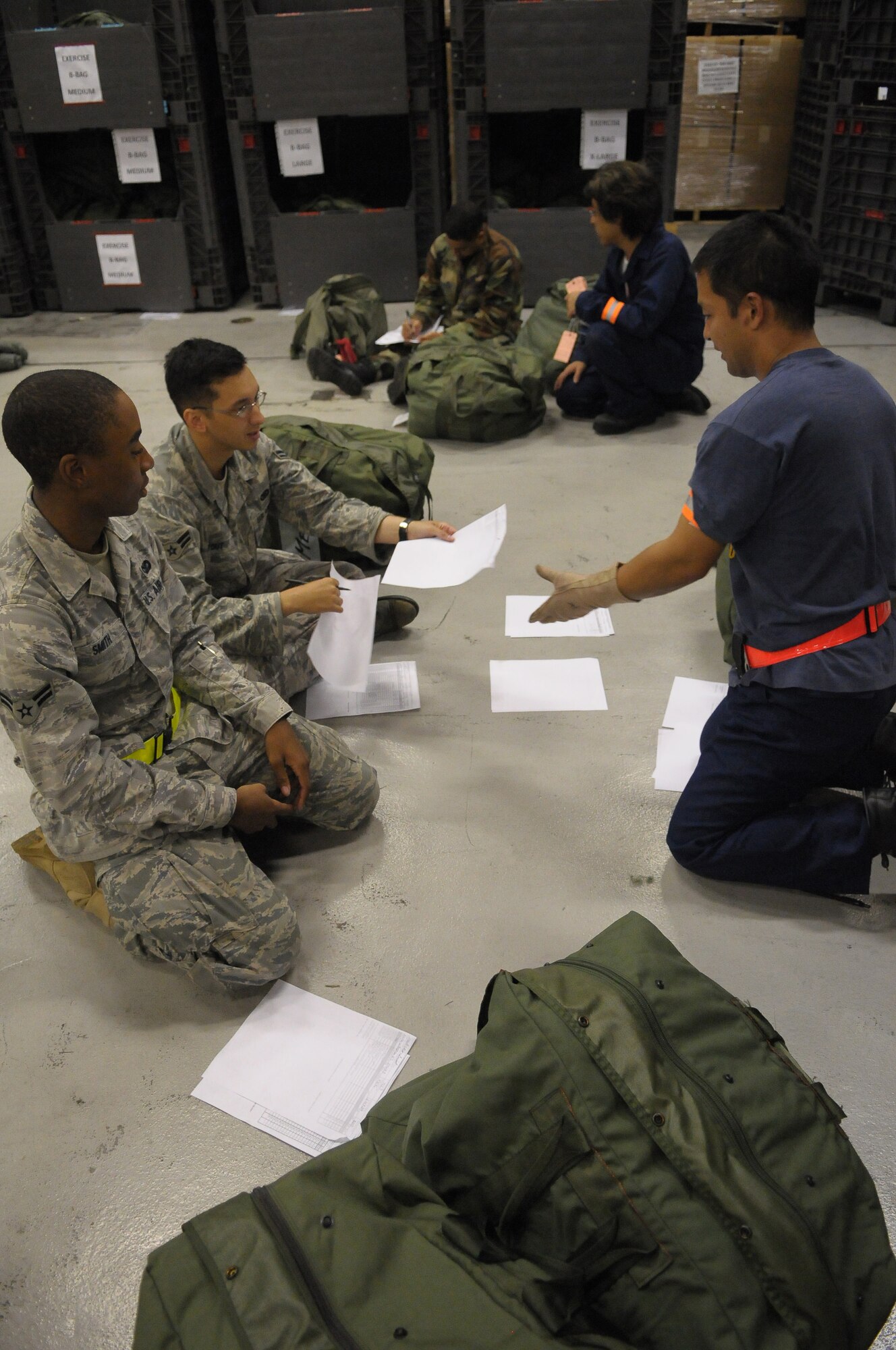 YOKOTA AIR BASE, Japan -- Airman 1st Class Wilbertson Smith and Airman 1st Class Andrew Stout, 374th Security Forces Squadron, gives a hand receipt for individual protective equipment to Morivama Takeshi, 374th Logistics Readiness Squadron, during Beverly-Bearcat 09-05, an operational readiness inspection conducte by the Pacific Air Forces Inspector General. (U.S. Air Force photo/Airman 1st Class Michael Dillon)
