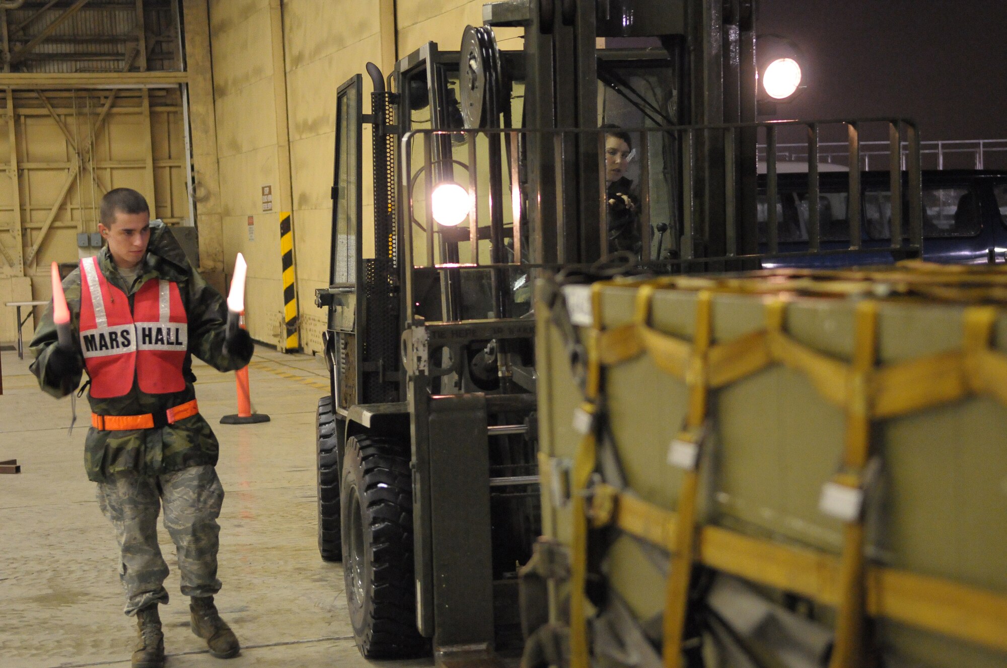 YOKOTA AIR BASE, Japan -- Airman 1st Class Justin Rose, 374th Logistics Readiness Squadron, spots Senior Airman Leela Sutton, 374th LRS, as she moves a pallet of supplies during Beverly-Bearcat 09-05, an operational readiness inspection conducte by the Pacific Air Forces Inspector General. (U.S. Air Force photo/Airman 1st Class Michael Dillon)
