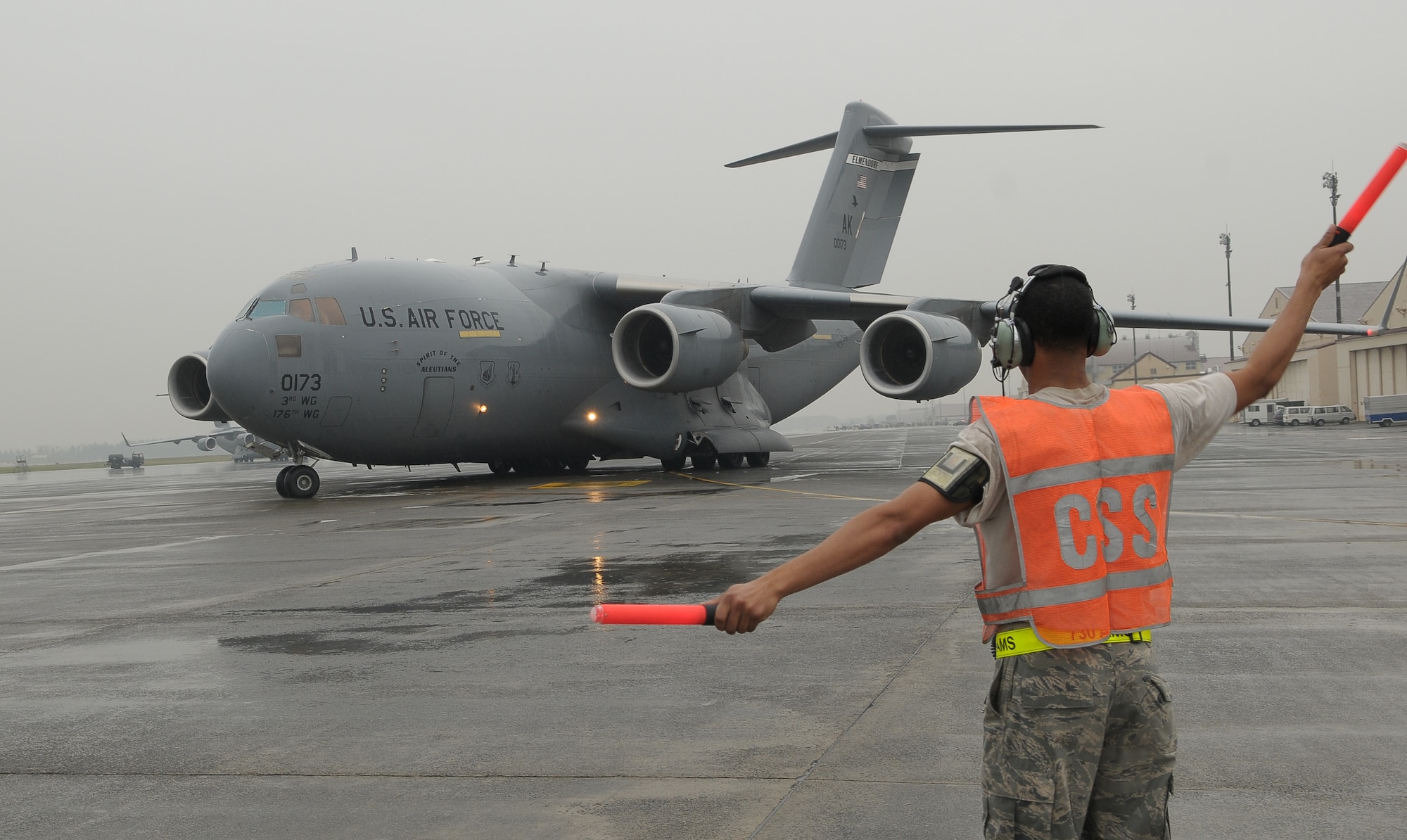 YOKOTA AIR BASE, Japan -- Senior Airman Ronald Carter, 730th Air Mobility Squadron, marshals out a C-17 Globemaster III from Elmendorf Air Force Base, Alaska, Oct. 5 on a mission to transport 26 members of an Air Force Humanitarian Assistance Rapid Response Team and a seven-person mobile field surgical team en route to Padang, Indonesia, to provide medical care to those affected by the recent 7.6-magnitude earthquake. A crew from Elmendorf transported the team and the equipment necessary to support the team, which is self-sustaining for up to five days. (U.S. Air Force photo/Airman 1st Class Sean Martin)