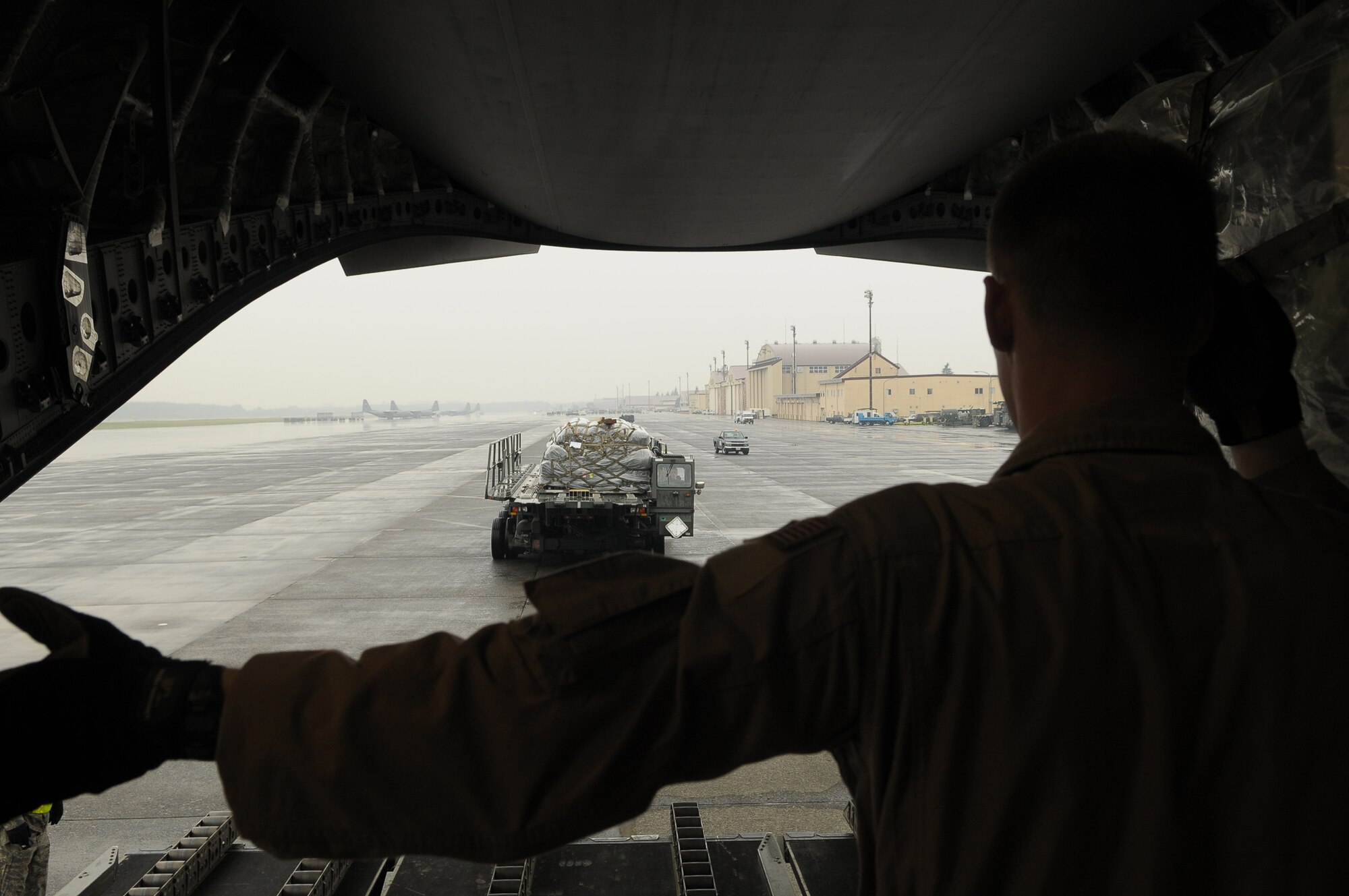 YOKOTA AIR BASE, Japan -- A loadmaster from Elmendorf Air Force Base, Alaska, directs the loading of one of 13 pallets of equipment accompanying 26 members of an Air Force Humanitarian Assistance Rapid Response Team and a seven-person mobile field surgical team which left here at 3:30 p.m. Oct. 5 en route to Padang, Indonesia, to provide medical care to those affected by the recent 7.6-magnitude earthquake. A C-17 Globemaster III crew from Elmendorf transported the team and the equipment necessary to support the team, which is self-sustaining for up to five days. (U.S. Air Force photo/Airman 1st Class Sean Martin)