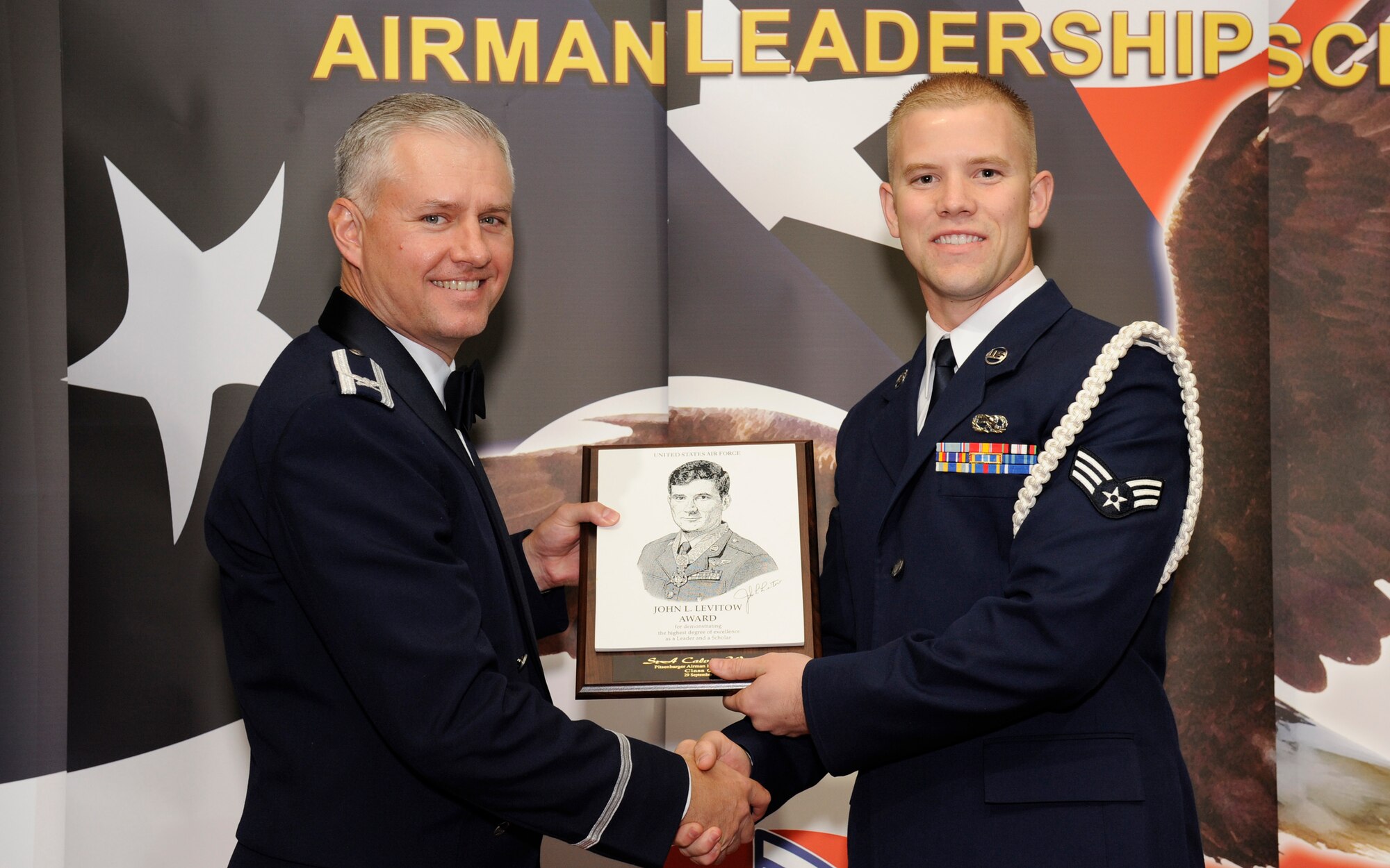 SPANGDAHLEM AIR BASE, Germany – Col. Kevin Anderson, 52nd Fighter Wing vice commander, presents the John L. Levitow Award to Senior Airman Calvin Woody, 52nd Aircraft Maintenance Squadron, during the Airman Leadership School class 09-8 graduation Sept. 29 at Club Eifel.  (U.S. Air Force photo/Master Sgt. Bill Gomez)