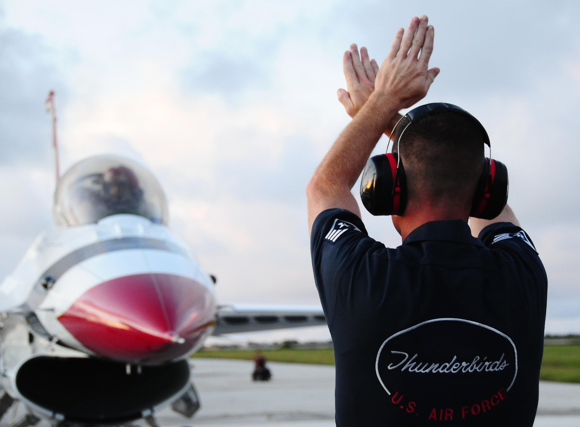 ANDERSEN AIR FORCE BASE, Guam - A maintainer with the U.S. Air Force Thunderbirds signals for his pilot to stop Oct. 5 on arrival to Andersen AFB.  The team arrived in preparation for Andersen AFB's Oct. 7 air show. The base rescheduled its air show for Oct. 7 after canceling it due Typhoon Melor.  The U.S. Air Force Thunderbirds is the premier aerial demonstration team representing Airmen worldwide. (U.S. Air Force photo by Senior Airman Nichelle Anderson/Released)