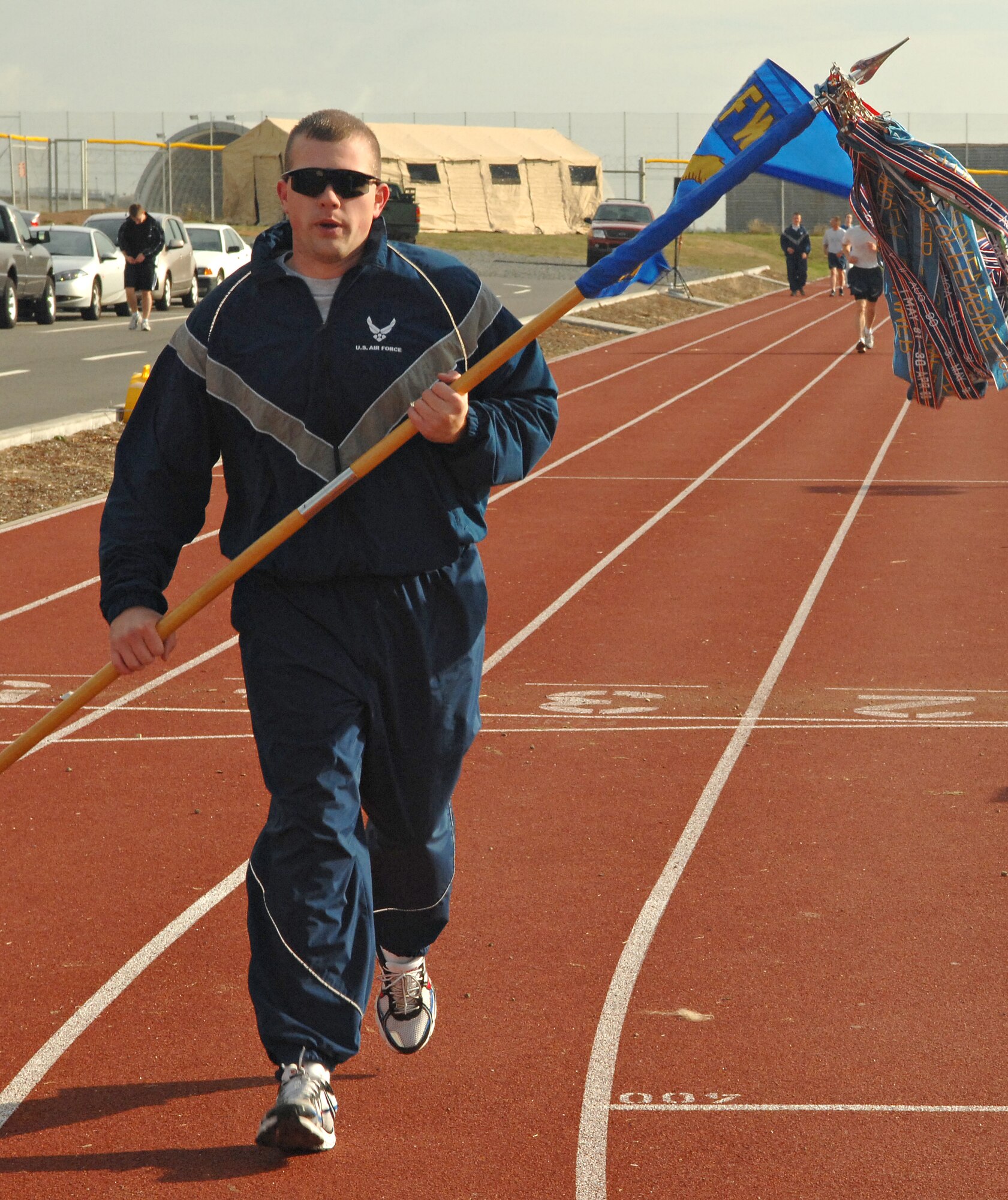 SPANGDAHLEM AIR BASE, Germany – Staff Sgt. Steven Schexnayder, 606th Air Control Squadron, carries his unit’s guideon during a 24 hour run/walk to raise money for Operation Warmheart here Oct. 2. People participating in the run raised money through pledges for Operation Warmheart, which benefits Spangdahlem Airmen in times of financial need. (U.S. Air Force photo/Senior Airman Benjamin Wilson)