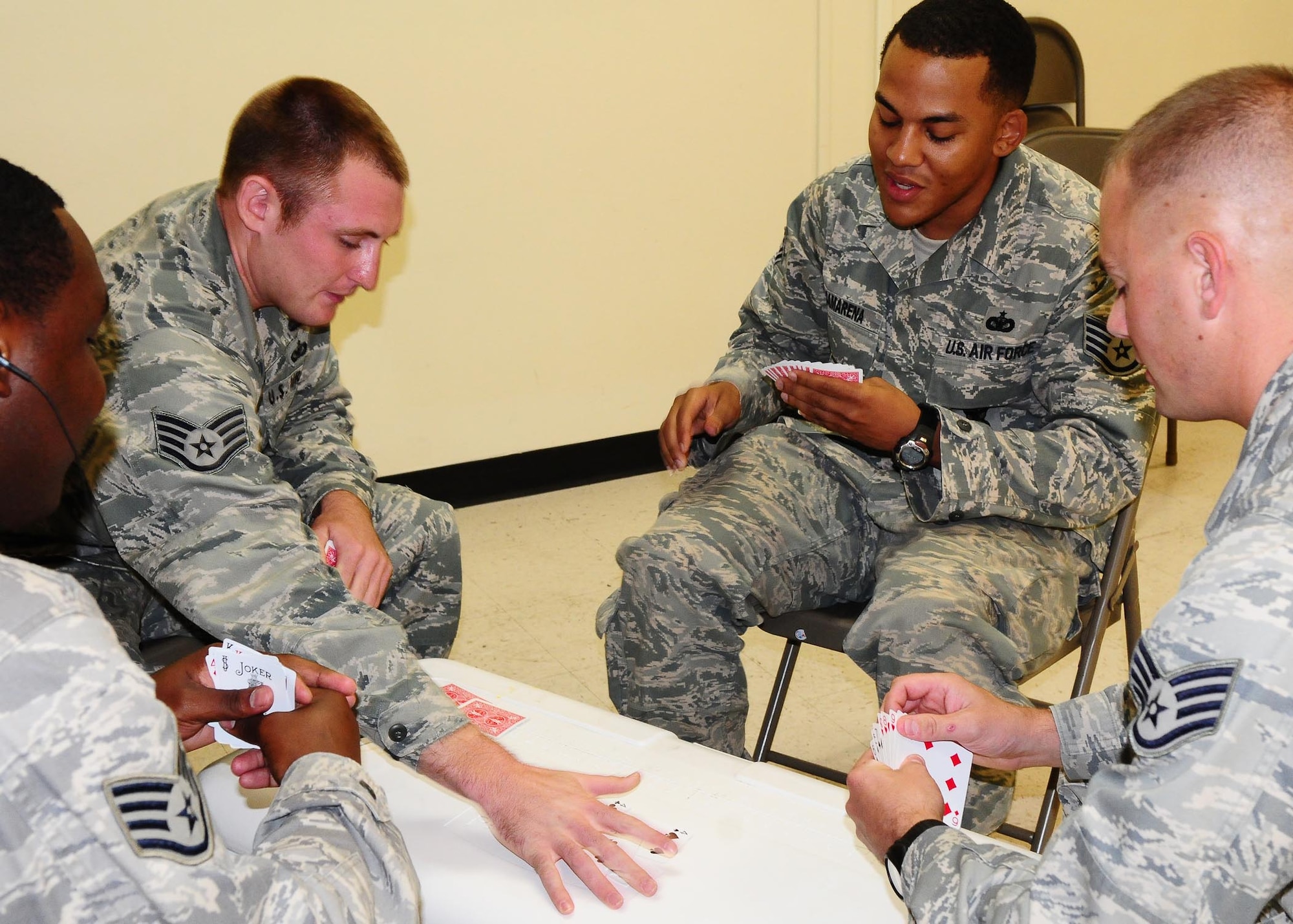 Airmen play a game of spades to pass time in mobility deployment processing before boarding the aircraft at Andersen Air Force Base, Guam. The Airmen are apart of a Humanitarian Aid Rapid Response Team deploying to Indonesia. Airmen from the 36th Contingency Response Group and the 36th Medical Group make up the HARRT team. An earthquake measuring 7.6 on the Richter scale struck West Sumatra province on Sept. 30, near Padang, and several strong aftershocks have followed, causing major damage and loss of life.    (U.S. Air Force photo by Senior Airman Nichelle Anderson)(Released)  