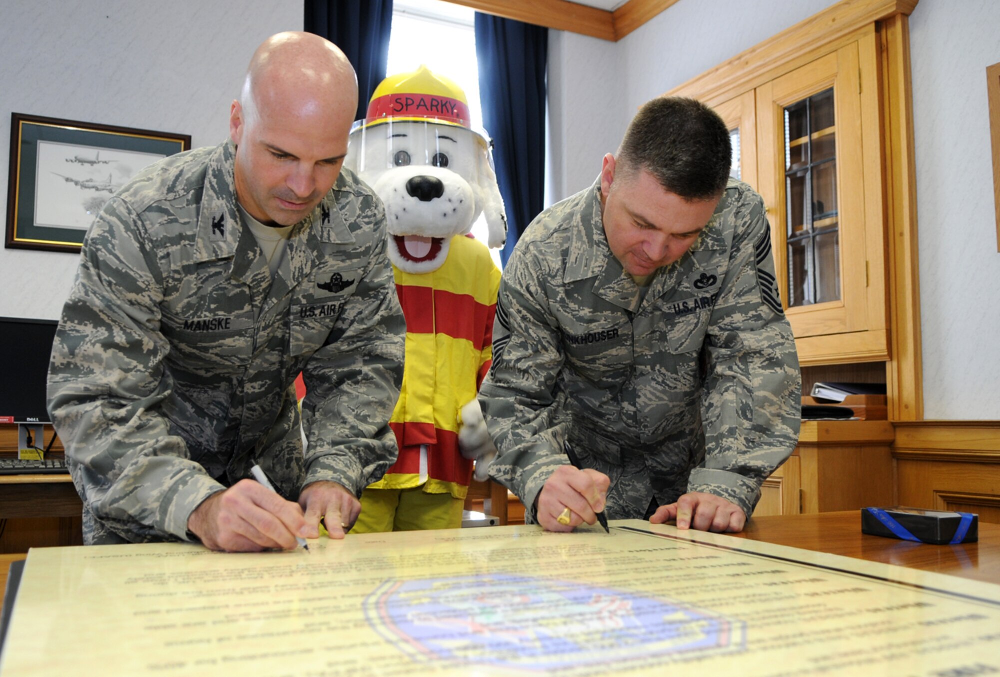 RAF MILDENHALL, England -- Col. Chad Manske, 100th Air Refueling Wing commander, and Chief Master Sgt. Charles Funkhouser, RAF Mildenhall fire chief, sign the proclamation officially kicking off Fire Prevention Week 2009 Oct. 2.  (U.S. Air Force photo/Staff Sgt. Austin M. May)