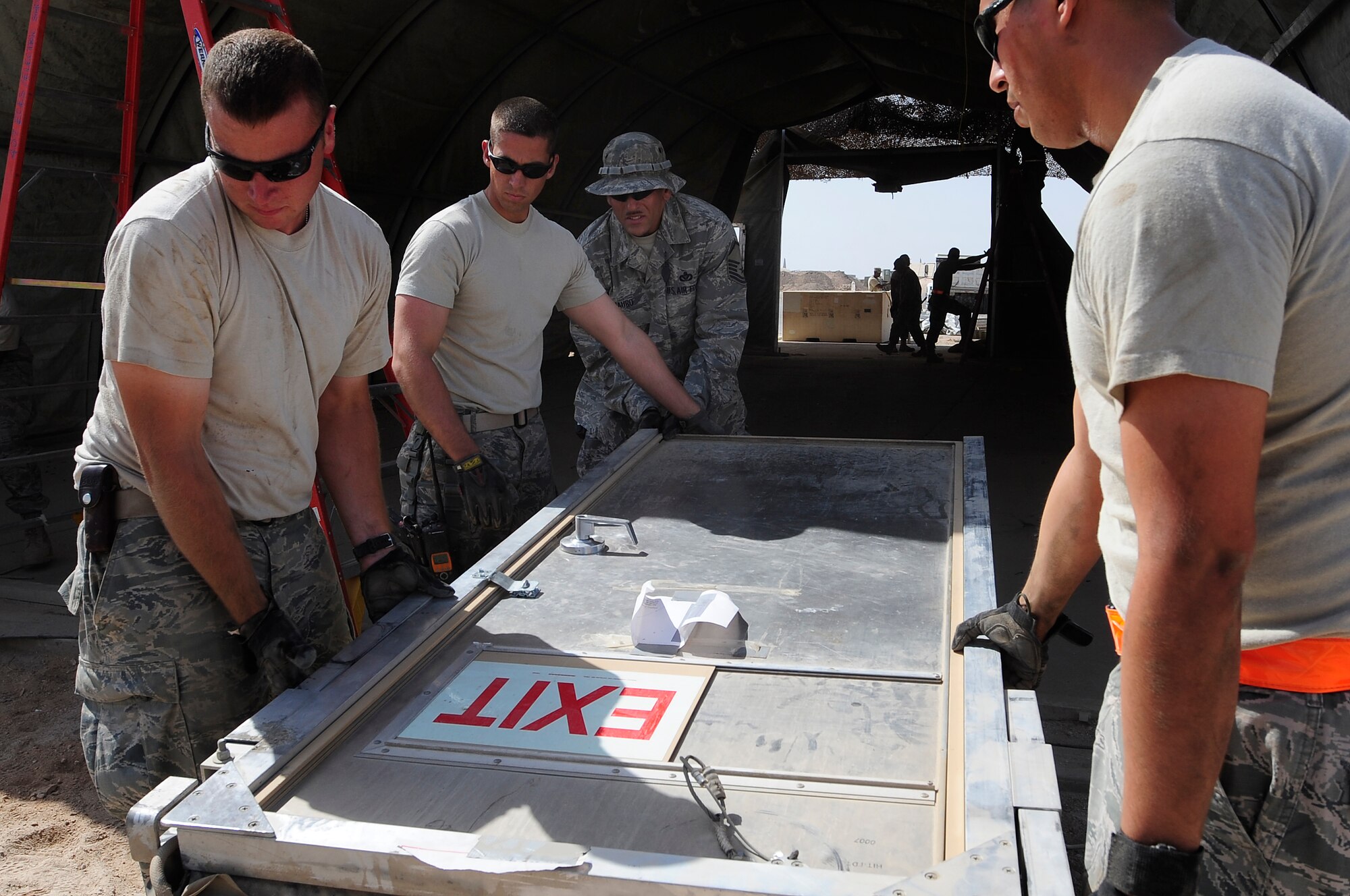 ALI BASE, Iraq – U.S. Air Force members of the 407th Expeditionary Civil Engineer Squadron take down a tent structure that had previously been used within their compound here, Sept. 30, 2009. The squadron has been downsizing; consolidating material and equipment to send to U.S. war fighters in Afghanistan. (U.S. Air Force photo/ Senior Airman Tony R. Ritter)