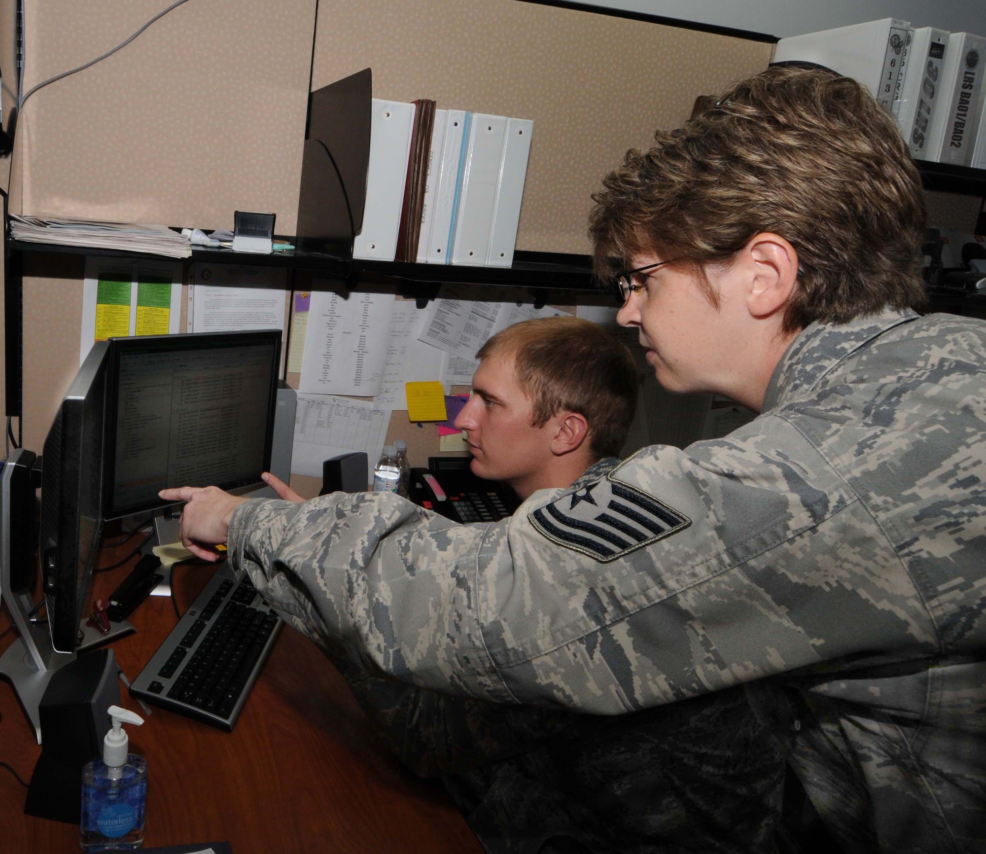 ANDERSEN AIR FORCE BASE, Guam - Tech. Sgt. Sharon Westerkamp assists 2nd Lt. Matthew Gensic in reviewing the status of the 36th Wing's financial account Oct. 1 here. Sergeant Westerkamp and Lieutenant Gensic are both budget analysts assigned to the 36th Comptroller Squadron. Sergeant Westerkamp was recognized as 'Top Performer' by her flight commander.   (U.S. Air Force photo by Airman 1st Class Julian North)
