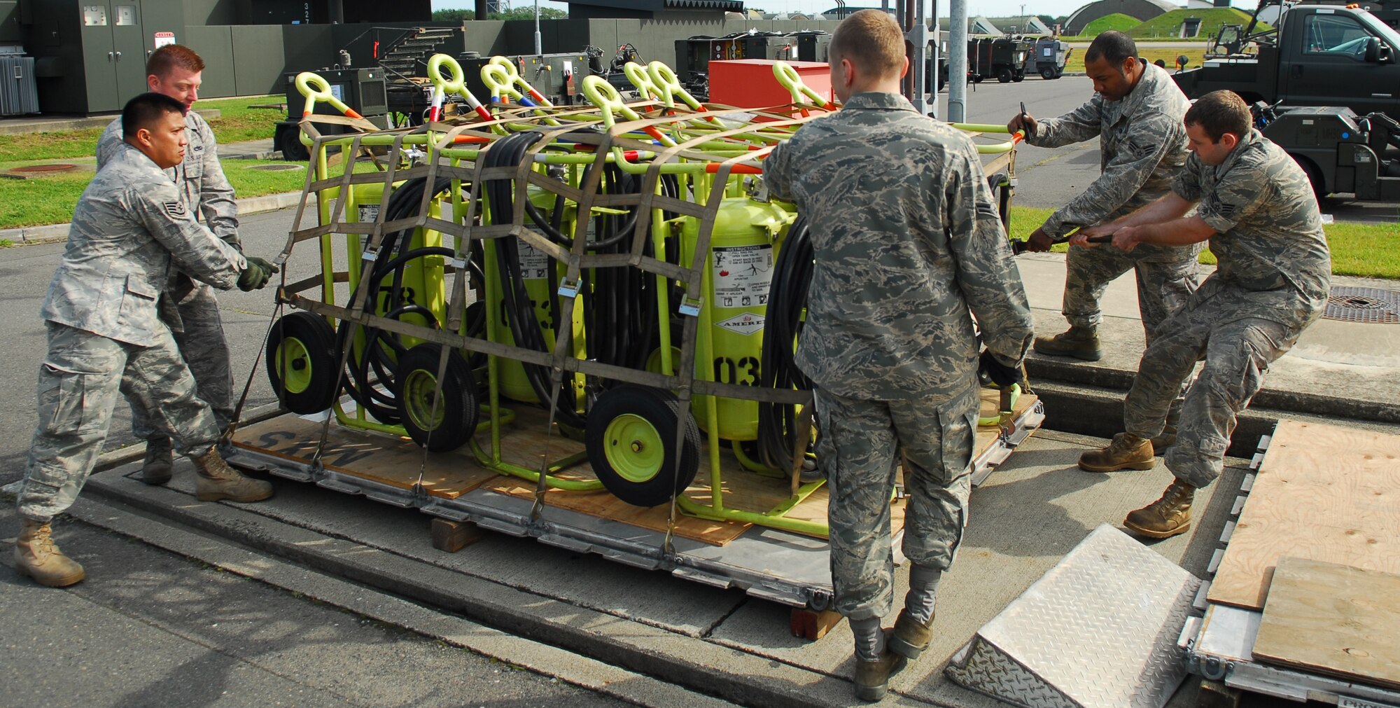 MISAWA AIR BASE, Japan—Airmen from the 13th Aircraft Maintenance Unit tighten a cargo net on flightline fire extinguishers Oct. 5 at Bldg. 3267. The extinguishers are being prepared as part of a deployment exercise. (U.S. Air Force Photo by Staff Sgt. Phillip Butterfield)