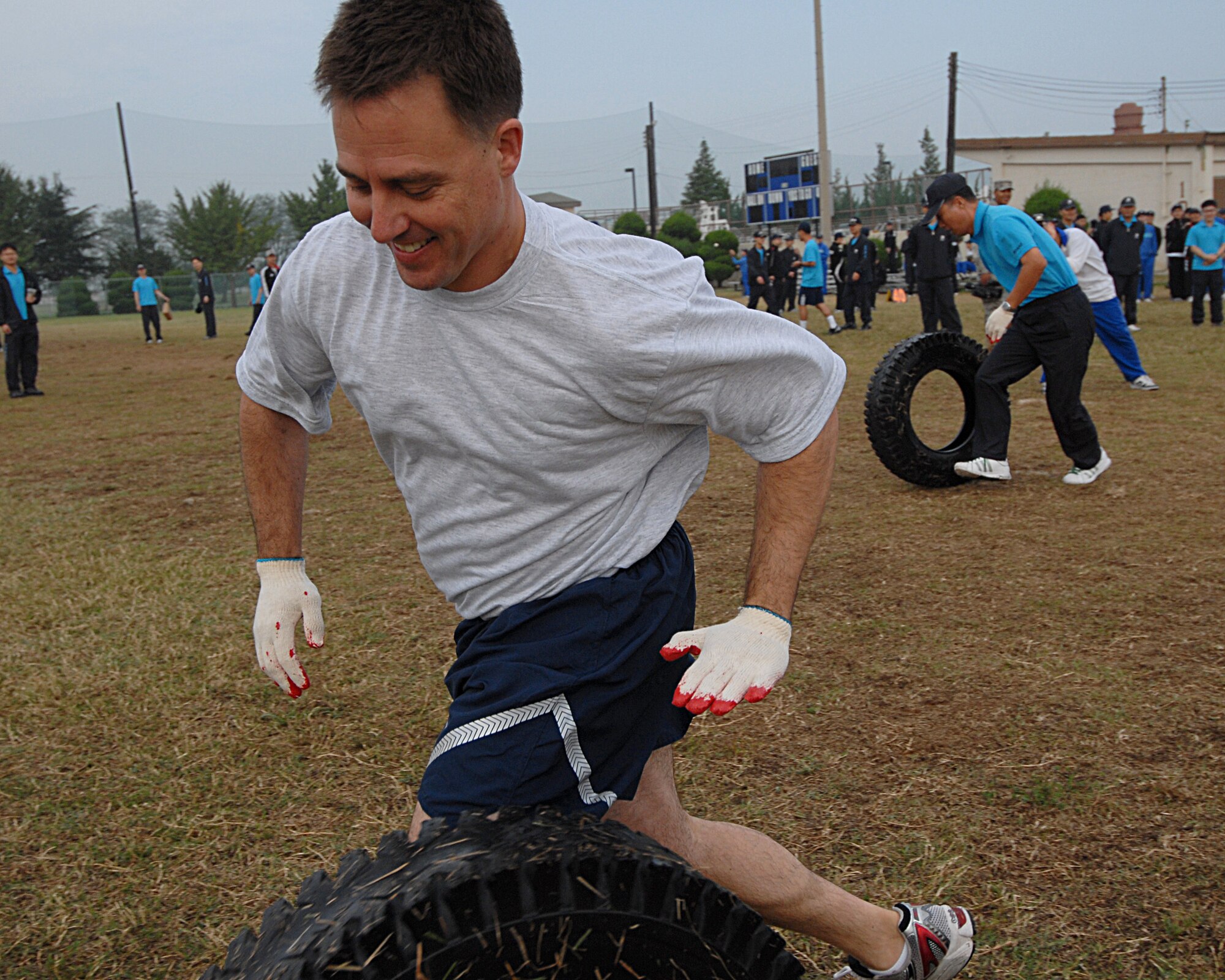 KUNSAN AIR BASE, Republic of Korea -- Col. Rob Givens, 8th Fighter Wing commander, rolls a tire down the width of the football field with Col. Oh, Chang Gyu, 38th Fighter Group commander, following Sept. 29. Both commanders were participating in Korean-American Sports Day. This event allowed Koreans and Americans the opportunity to come together in friendly competition. (U.S. Air Force Photo / Senior Airman Roy Lynch)