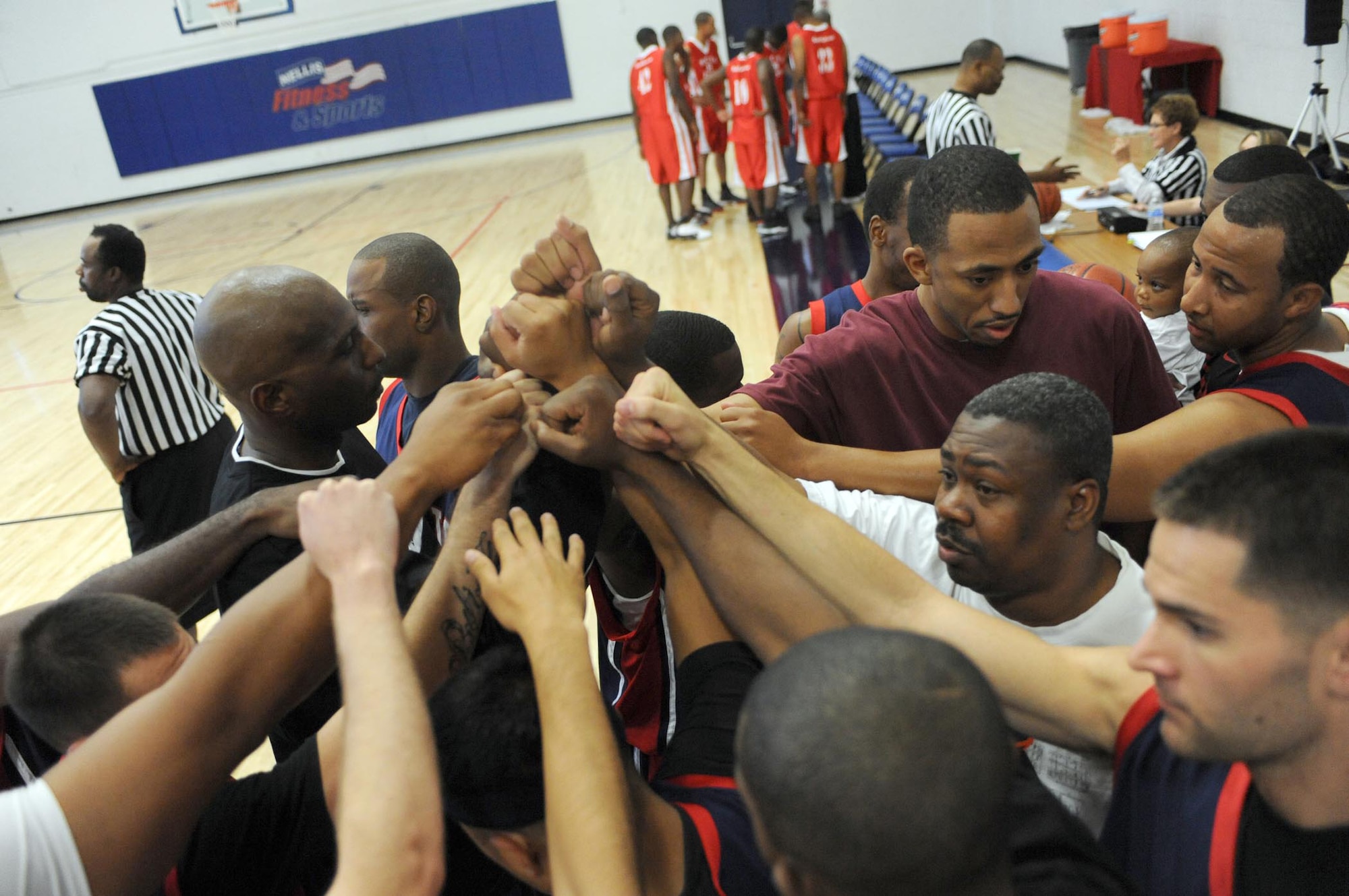 NELLIS AIR FORCE BASE, Nev.-- Nellis Men's Basketball Team talk in a huddle during a time-out. The Nellis team kicked off their season undefeated in Pacific West Military Athletic Conference play.  (U.S. Air Force photo by Tech. Sgt. Michael R. Holzworth)
