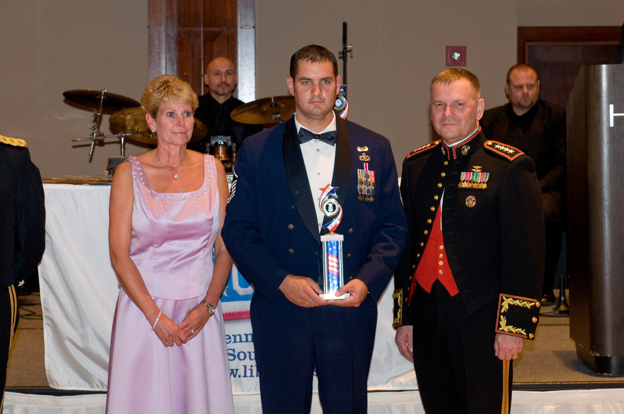 Master Sgt. Bubba Beason holds the Service Member of the Year award, Liberty USO's highest military honor, Oct. 2 at the Annual Liberty USO Gala. He is standing between Tracy Carter Dougherty, Chairman of the Board of Directors, Liberty USO, and  General James E. Cartwright, Vice Chairman of the Joint Chiefs of Staff.  (U.S. Air Force courtesty photo)
