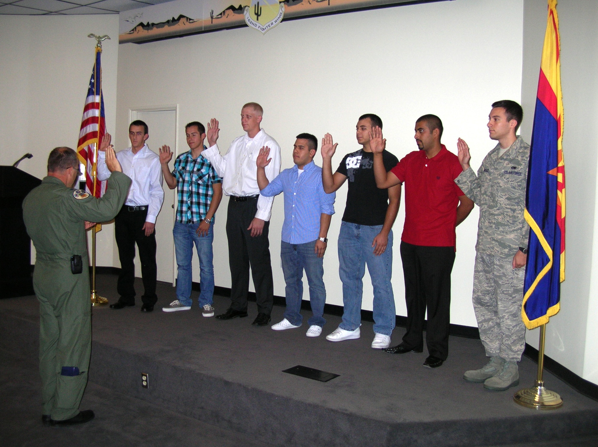 Col. Greg Stroud, 162nd Fighter Wing commander, administers the oath of enlistment to nine new members in the wing auditorium here, Oct. 2. (Air National Guard photo by Master Sgt. Johnny Martinez)