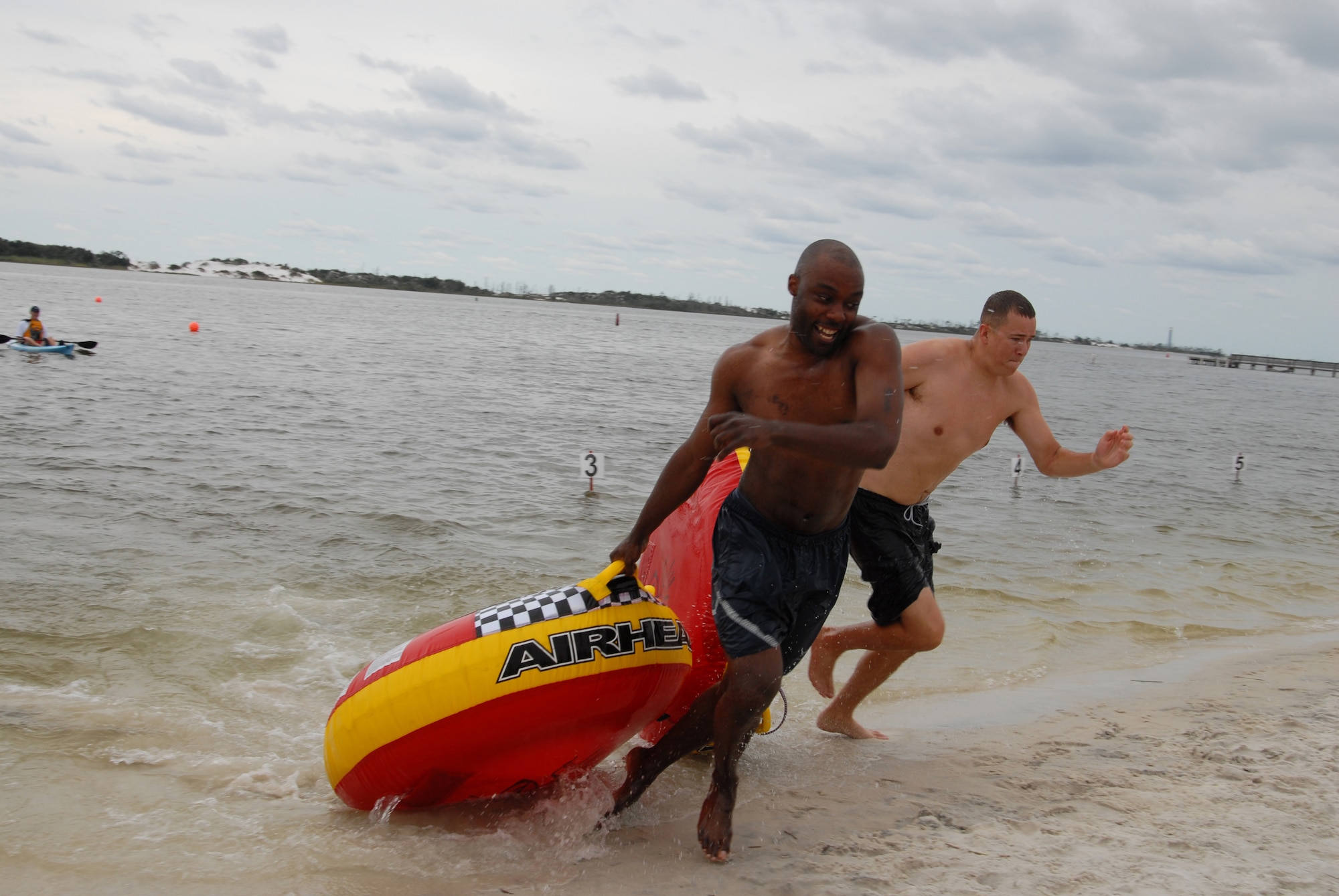 U.S. Air Force Staff Sgt. Briane Rock, 1st Special Operations Force Support Squadron (left), and 1st Lt. Andrew Burns, 413th Flight Test Squadron (right), race to the finish line in the inner tube relay race during the H2Olympics at Hurlburt Field, Fla., Oct. 2, 2009. (U. S. Air Force photo by Staff Sgt. Orly N. Tyrell)