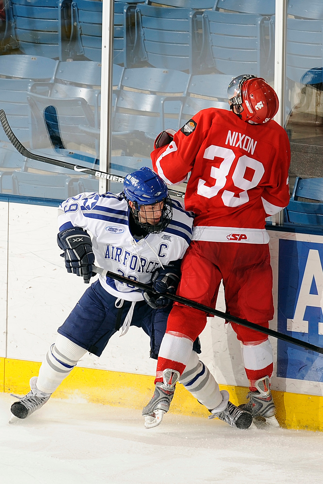 Air Force senior forward Brett Nylander checks Calgary's Brock Nixon during an exhibition game between the Falcons and the Dinos at the Cadet Ice Arena Oct. 5, 2009. Air Force won the exhibition match 3-1. Air Force will play its first regular-season game at Bemidji State in Bemidji, Minn., Oct. 9. (U.S. Air Force photo/Bill Evans)