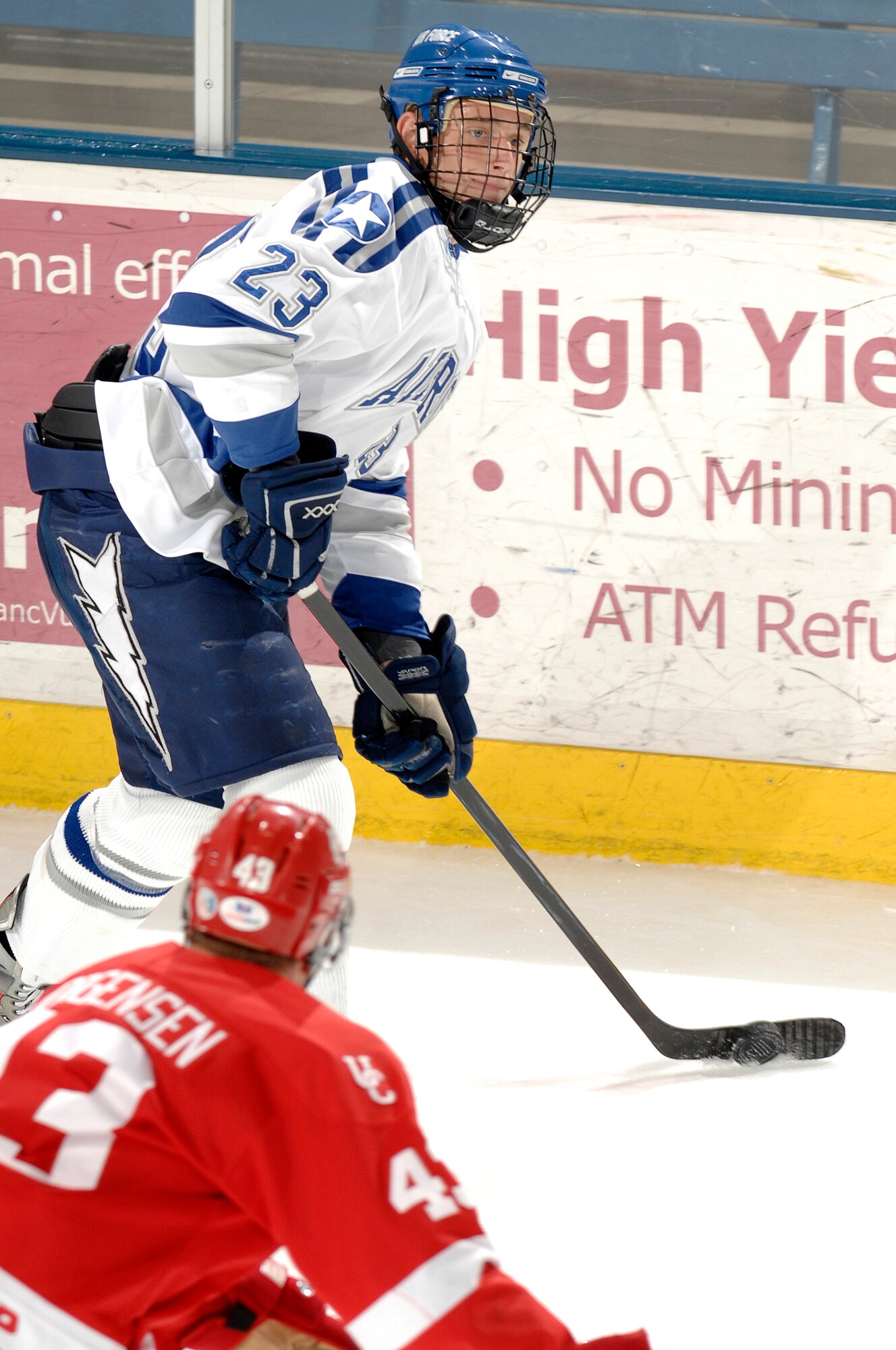 Air Force sophomore defender Scott Mathis moves the puck down the ice as Calgary forward Reid Jorgensen moves to cover him during the Falcons-Dinos exhibition match at the Cadet Ice Arena Oct. 5, 2009. Air Force won the match 3-1 on two goals by senior forward Jacquees Lamoureux. Mathis is a native of Crystal Lake, Ill. (U.S. Air Force photo/Mike Kaplan)