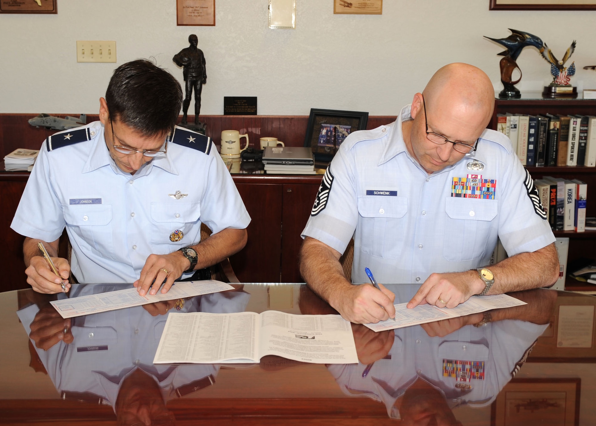 Brig. Gen. Paul Johnson, 355th Fighter Wing commander, and Chief Master Sgt.
Thomas Schwenk, 355th Fighter Wing command chief, each sign their Combined
Federal Campaign pledge forms Oct. 5 at the wing headquarters building. The
Davis-Monthan CFC runs from Sept. 16 to Oct. 31. For more information about
the CFC, contact Master Sgt. Jeffrey Ward, 228-7447, jeffrey.ward@dm.af mil, the base's overall representative. (U.S. Air Force photo/Airman 1st Class Brittany
Dowdle) 228-3600
