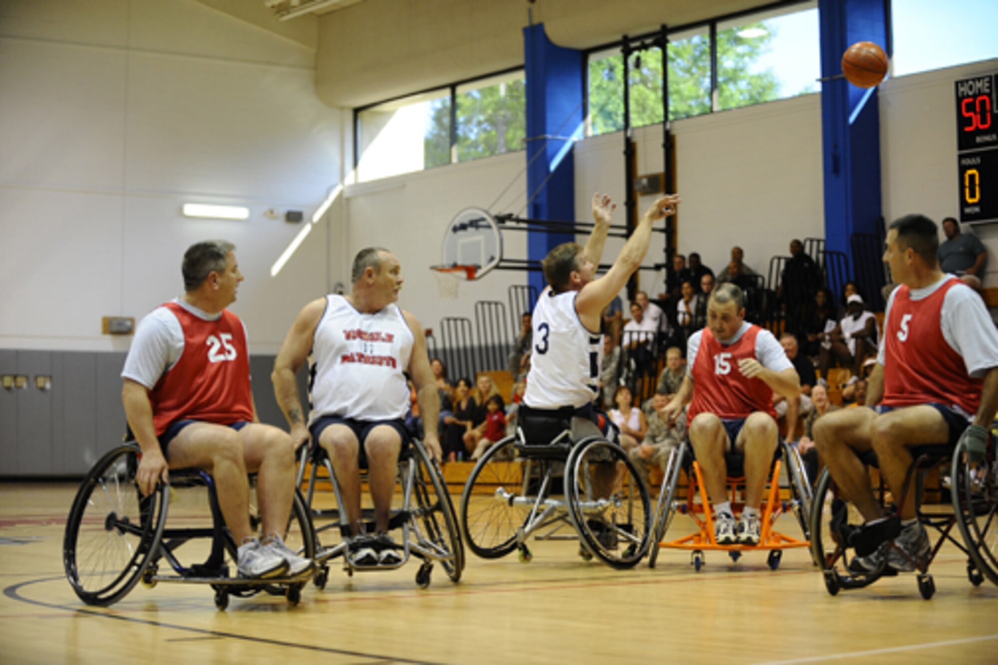 HURLBURT FIELD -- Col. Edward McKinzie, 505th Command and Control Wing commander, (No. 25) rolls with Hurlburt Field teammates during the fourth annual Wheelchair Basketball Exhibition Game against the Mobile Patriots Oct. 1 at Aderholt Fitness Center.The Mobile Patriots, a nonprofit wheelchair basketball team, defeated the Hurlburt Commandos 85-79, even after some creative scorekeeping.The game is played every October to recognize National Disability Employment Awareness month. The silent auction and concessions during the game raised nearly $4,000 for the Patriots' organization.  (U.S. Air Force photo by Senior Airman Julianne Showalter) 