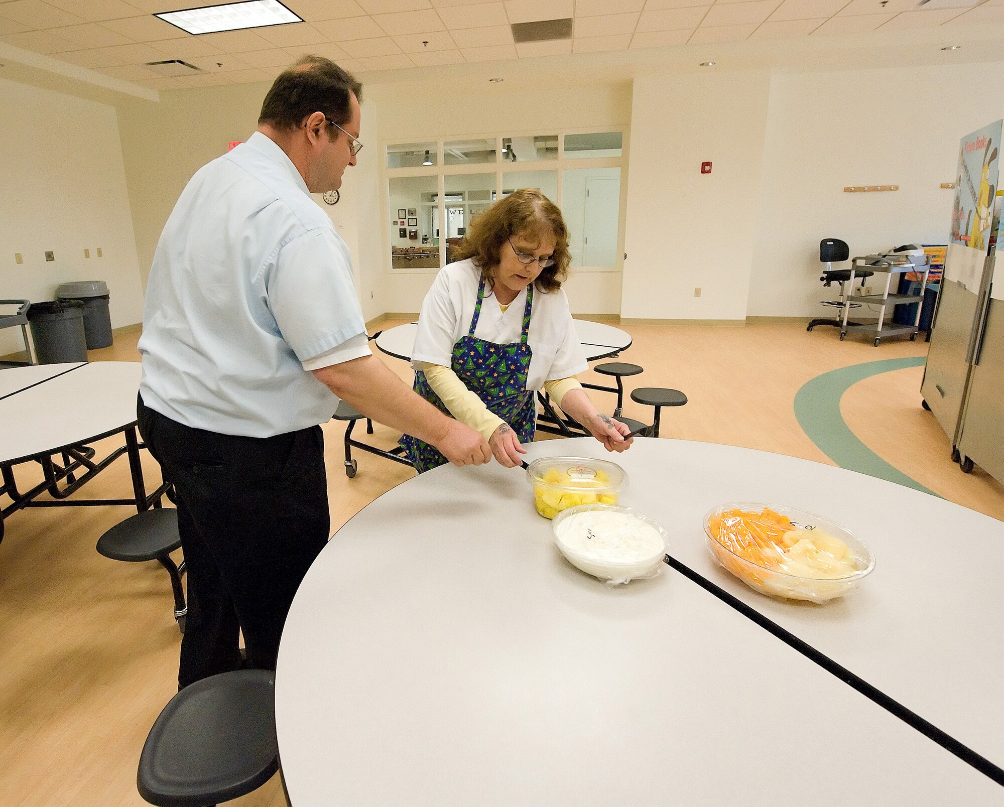 (Left to Right) Steve James, Youth Behavior consultant, assists Terri Hutchinson, 436th Force Support Squadron Youth Center cook, in setting up snacks for the children at the Youth Center. Ms. Hutchinson saved the life of Mr. James Sept. 9, when he began to choke on a carrot. (U.S. Air Force photo/Jason Minto)