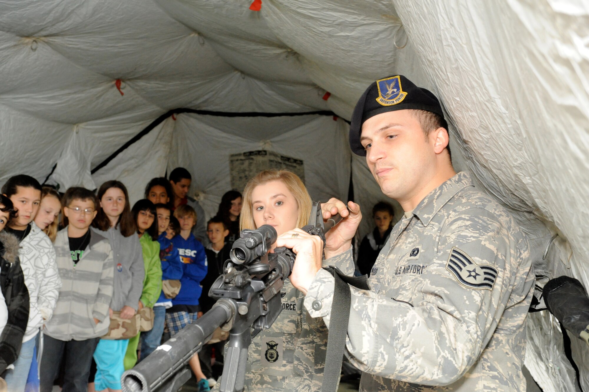 When the students’ simulated flight landed in Saudi Arabia, they were briefed by 87th Security Forces Squadron on weapons used in forward locations here, Oct. 2.  Upon return from their 'deployment', they were welcomed home with meals from the USO, and received a post-deployment briefing.  (U.S. Air Force photo/Wayne Russell)