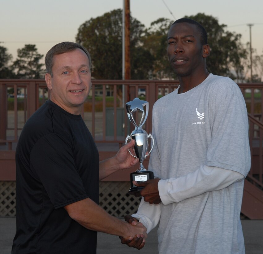 VANDENBERG AIR FORCE BASE, Calif. -- Team V's Male Athlete of the Year, Staff Sgt. Anthoney Kilgore, a 30th Launch Support Squadron facility integration mangager is awarded a trophy from Col. David Buck, the 30th Space Wing commander. The annual trophy is awarded based on participation and performance in intramural sports. (U.S. Air Force photo/Senior Airman Antionette Lyons)   