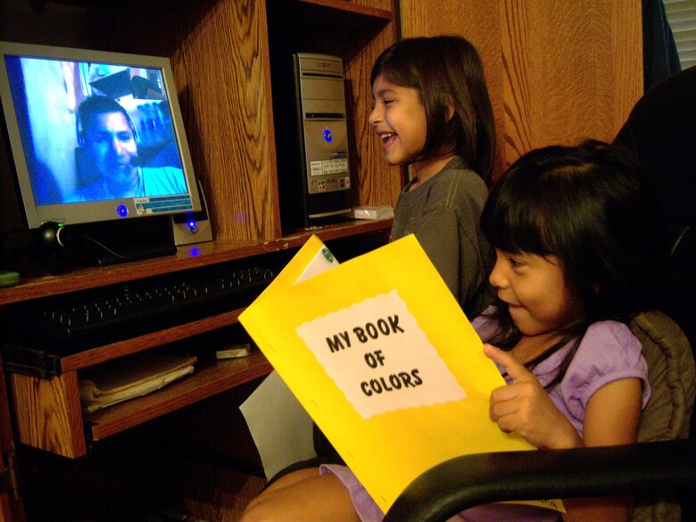 J.J. (standing) and Elena Gutierrez talk to their father over the Internet Sept. 26, 2009, from Randolph Air Force Base, Texas, while he's deployed to Bagram Airfield, Afghanistan. Staff Sgt. Juan Gutierrez, assigned to the 12th Dental Squadron, and his family use computers, Web cams and microphones to see and hear each other almost daily during his six-month deployment. (U.S. Air Force photo/Tech. Sgt. Sonny Cohrs) 