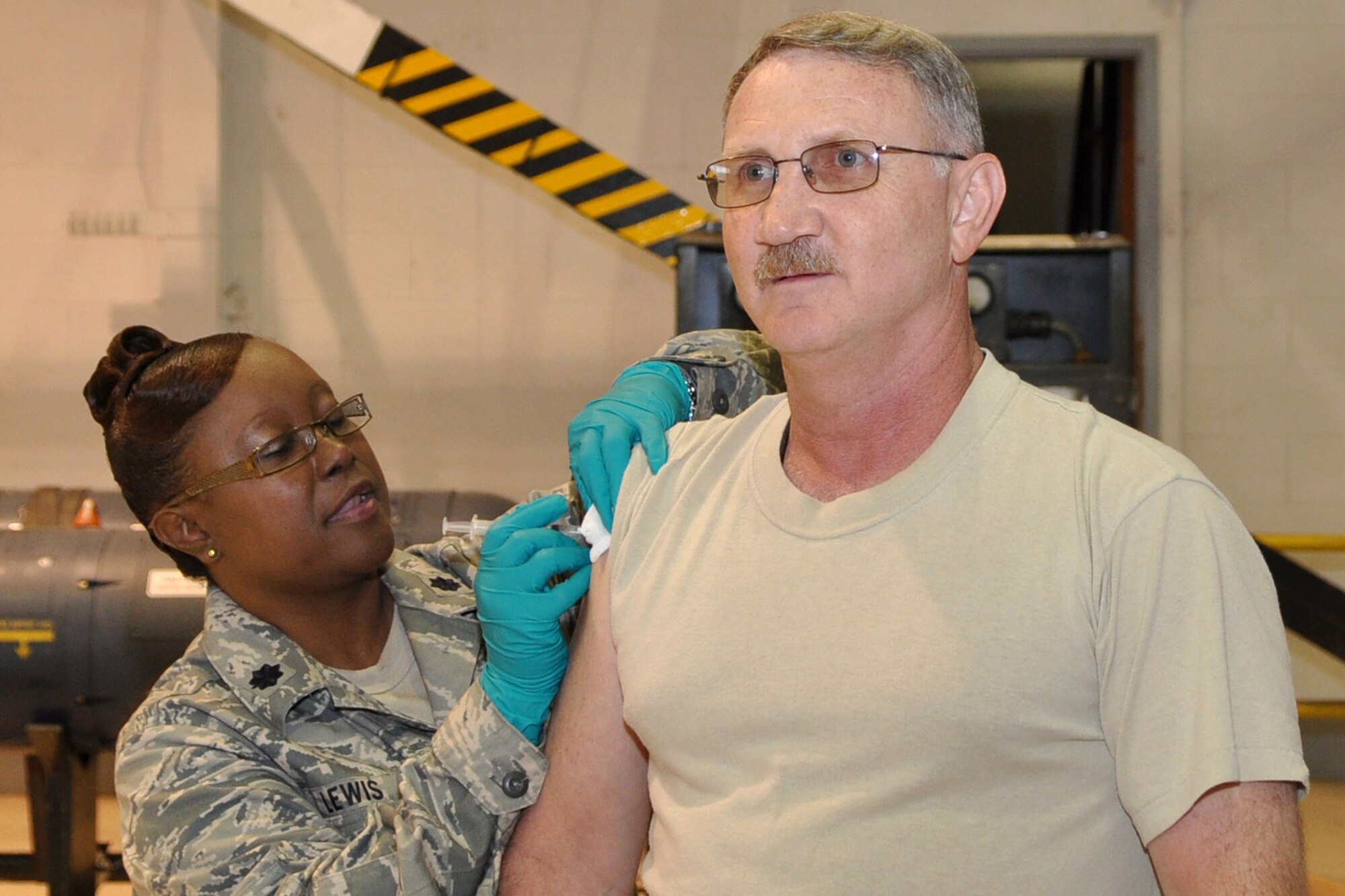 Technical Sgt. Jeff Walston, 917th Wing, public affairs technician, opts to receive the traditional needle injection of the “seasonal” influenza vaccine from Lt. Col. Beverly Lewis, 917th Medical Squadron, clinical nurse, in the A-10 Hangar at Barksdale Air Base, La., October 4, 2009. Unlike the flu mist, which is a live, attenuated (weakened) influenza vaccine sprayed into the nostrils, the “flu shot” is an inactivated (killed) vaccine, which is injected into the muscle. Influenza viruses are always changing. Because of this, influenza vaccines are updated every year, and an annual vaccination is recommended, but is mandatory for the military. These “seasonal” influenza vaccines are formulated to prevent annual flu, and do not protect against pandemic H1N1 influenza. It takes up to two weeks for protection to develop after the shot, and protection lasts up to a year. (U.S. Air Force photo/Tech. Sgt. Akerele Adeyemi) 