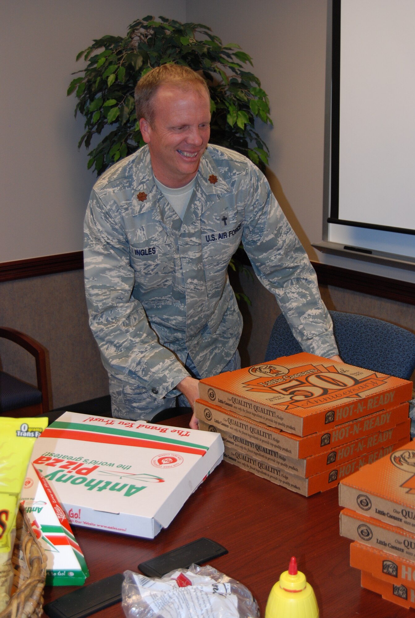 PETERSON AIR FORCE BASE, Colo. -- Chaplain (Maj.) Mark Ingles, delivers pizza Sept. 30, to Airmen and civilians working late to complete end of year purchases. Airmen and civilians worked into the night - some until 3 a.m - Oct. 1 – to capitalize on end of year funding for the wing. Their efforts translated into more than $9 million in additional funding for the wing. (U.S Air Force photo by Steve Brady)