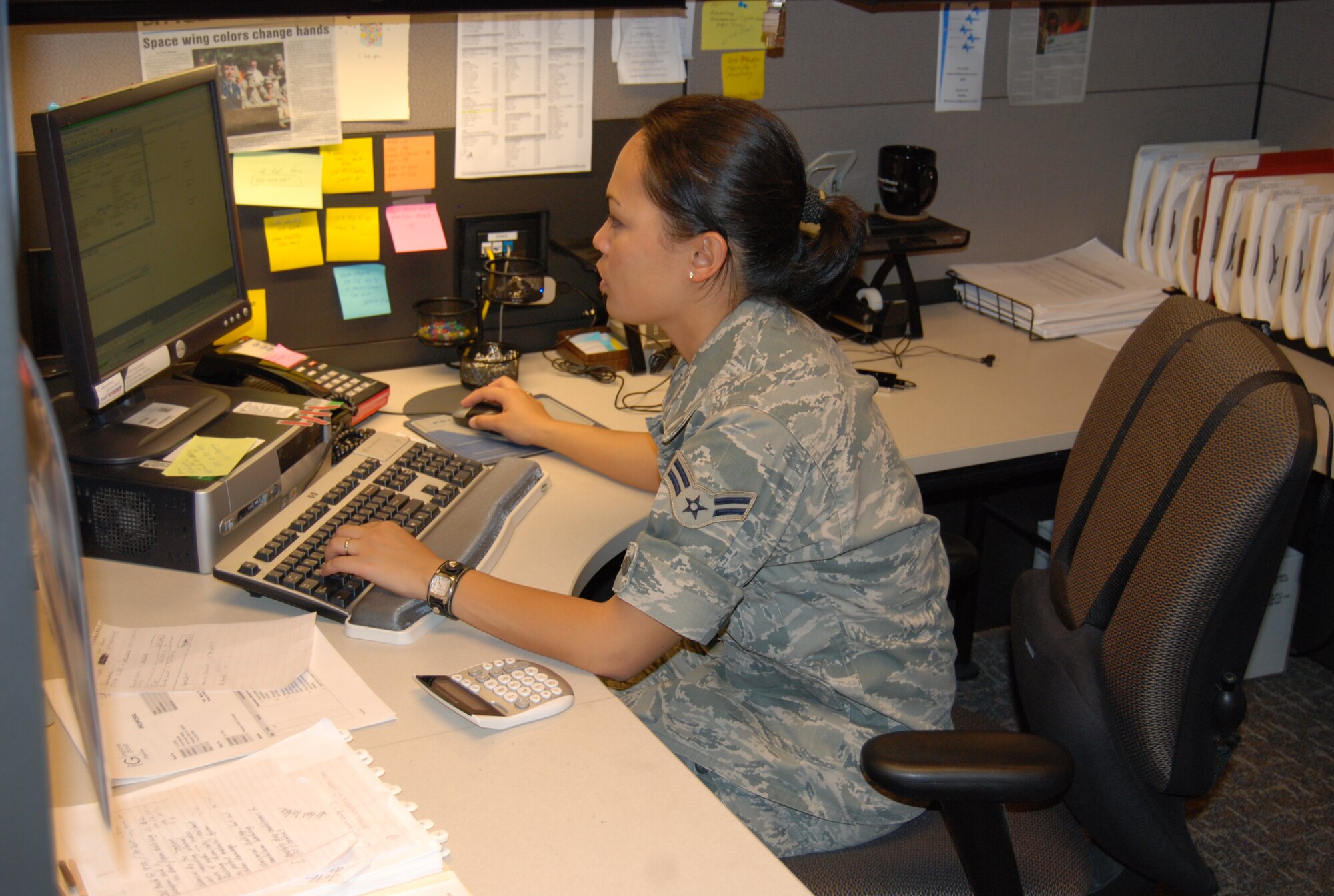 PETERSON AIR FORCE BASE, Colo. -- Airman 1st Class Anna Haenelt, 21st Contracting Squadron contract specialist, reviews documents as part of the end of year buying Sept. 30. Airmen and civilians worked into the night – some working until 3 a.m. Oct. 1 – to capitalize on end of year funding for the wing. Their hard work and dedication translated into more than $9 million in additional funding for the wing. (Air Force photo by Steve Brady)