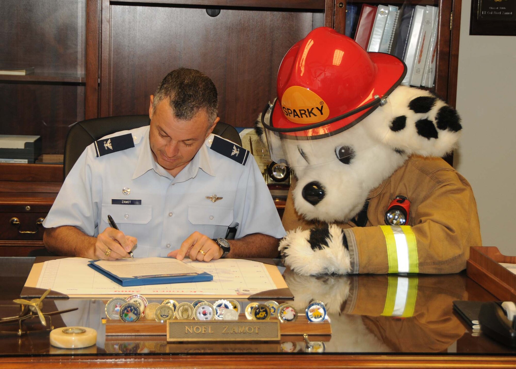 ALTUS AIR FORCE BASE, Okla. -- Col. Noel Zamot, 97th Mission Support Group Commander, signs the Fire Prevention Proclamation with Sparky Oct. 5.The proclamation is to help ensure the education and awareness of fire safety for the Altus Air Force Base community. (U.S. Air Force Photo/Senior Airman Marianne E. Lane)