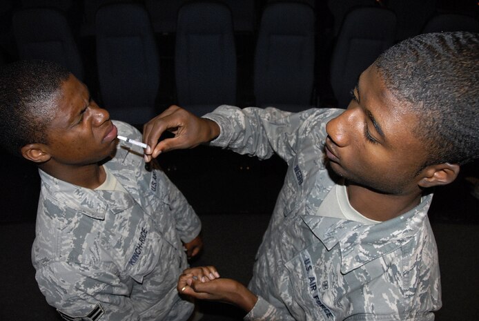 Airman 1st Class Reco Webb prepares to give Airman 1st Class Anthonyo Kinch-Rice the nasal flu mist vaccination at the base theater here Oct. 2. Flu season typically runs from October to June and all active-duty Airmen are required to receive a flu vaccination annually. Airman Webb is a medical technician with the 437th Medical Group and Airman Kinch-Rice is an entry controller with the 437th Security Forces Squadron. (U.S. Air Force photo/Staff Sgt. Daniel Bowles)