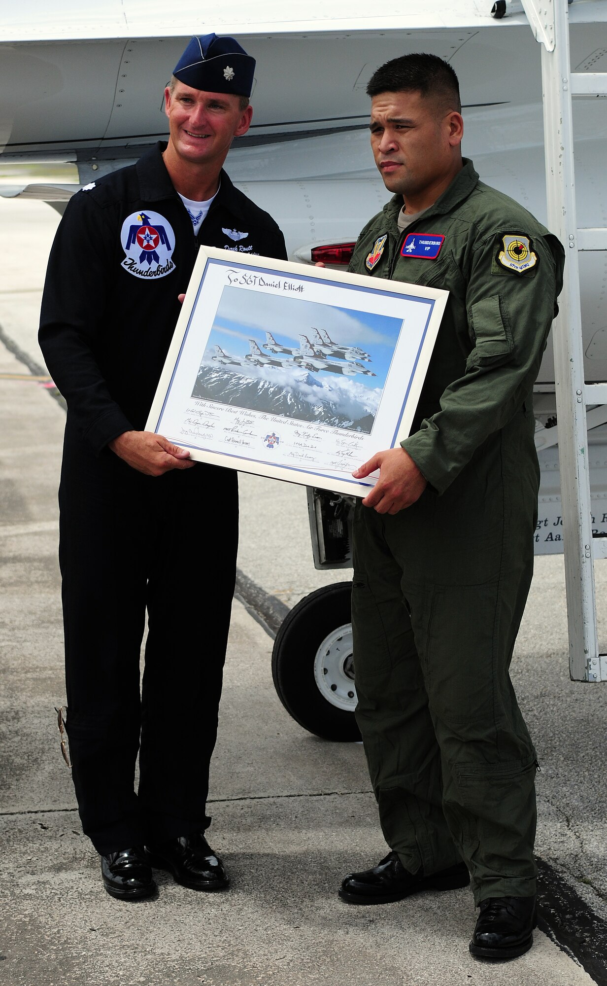 ANDERSEN AIR FORCE BASE, Guam -  U.S. Air Force Aerial Demonstration Squadron Pilot Lt. Col. Derek Routt  presents Army Sgt. Dan Elliott with a token of appreciation here Oct. 6 for his service in the Guam Army National Guard and for his heroism during his deployment in Afghanistan May 2008. The Thunderbirds flew Sgt. Elliott in the back seat of an F-16 Falcon over Andersen AFB and the island of Guam. The Thunderbirds are scheduled to perform an air show over Andersen AFB Oct. 7. (U.S. Air Force photo by Airman 1st Class Courtney Witt)