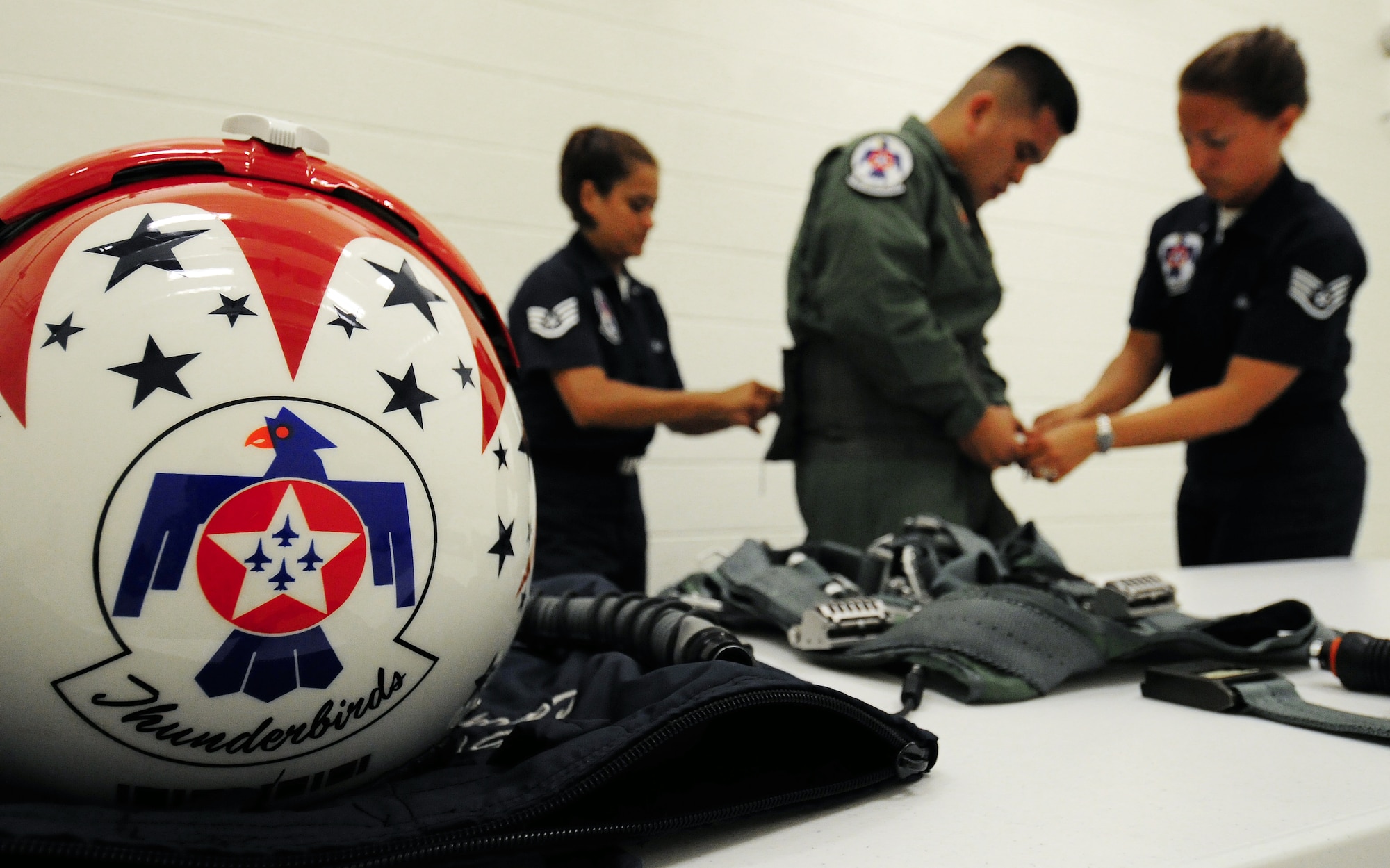 ANDERSEN AIR FORCE BASE, Guam - Staff Sgt. Robbin Bailon, U.S. Air Force Thunderbirds assistant flight equipment,and Staff Sgt. Kristi Machado, Thunderbirds Aerial Photographer, fits Army Sgt. Dan Elliott with life support gear before his Hometown Hero Flight Oct. 6. The Thunderbirds flew Sgt. Elliott in the back seat of an F-16 Falcon over Andersen AFB and the island of Guam. The Thunderbirds are scheduled to perform in an air show over Andersen AFB Oct. 7. (U.S. Air Force photo by Airman 1st Class Courtney Witt)