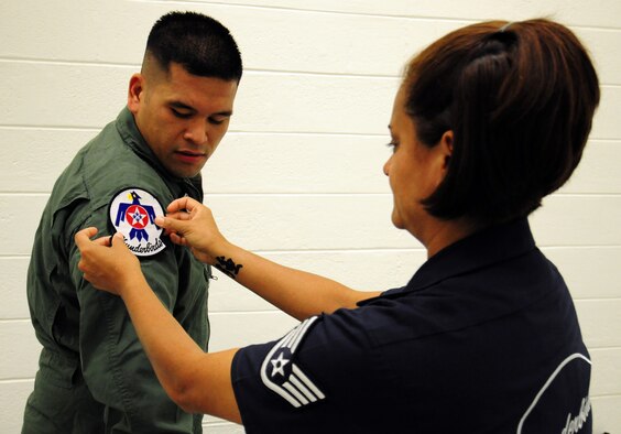 ANDERSEN AIR FORCE BASE, Guam - Staff Sgt. Robbin Bailon, U.S. Air Force Thunderbirds assistant flight equipment, places the Thunderbird patch on Army Sgt. Dan Elliott here Oct. 6 before his Hometown Hero Flight. The Thunderbirds flew Sgt. Elliott in the back seat of an F-16 Falcon over Andersen AFB and the island of Guam. The Thunderbirds are scheduled to perform in an air show over Andersen AFB Oct. 7. (U.S. Air Force photo by Airman 1st Class Courtney Witt)