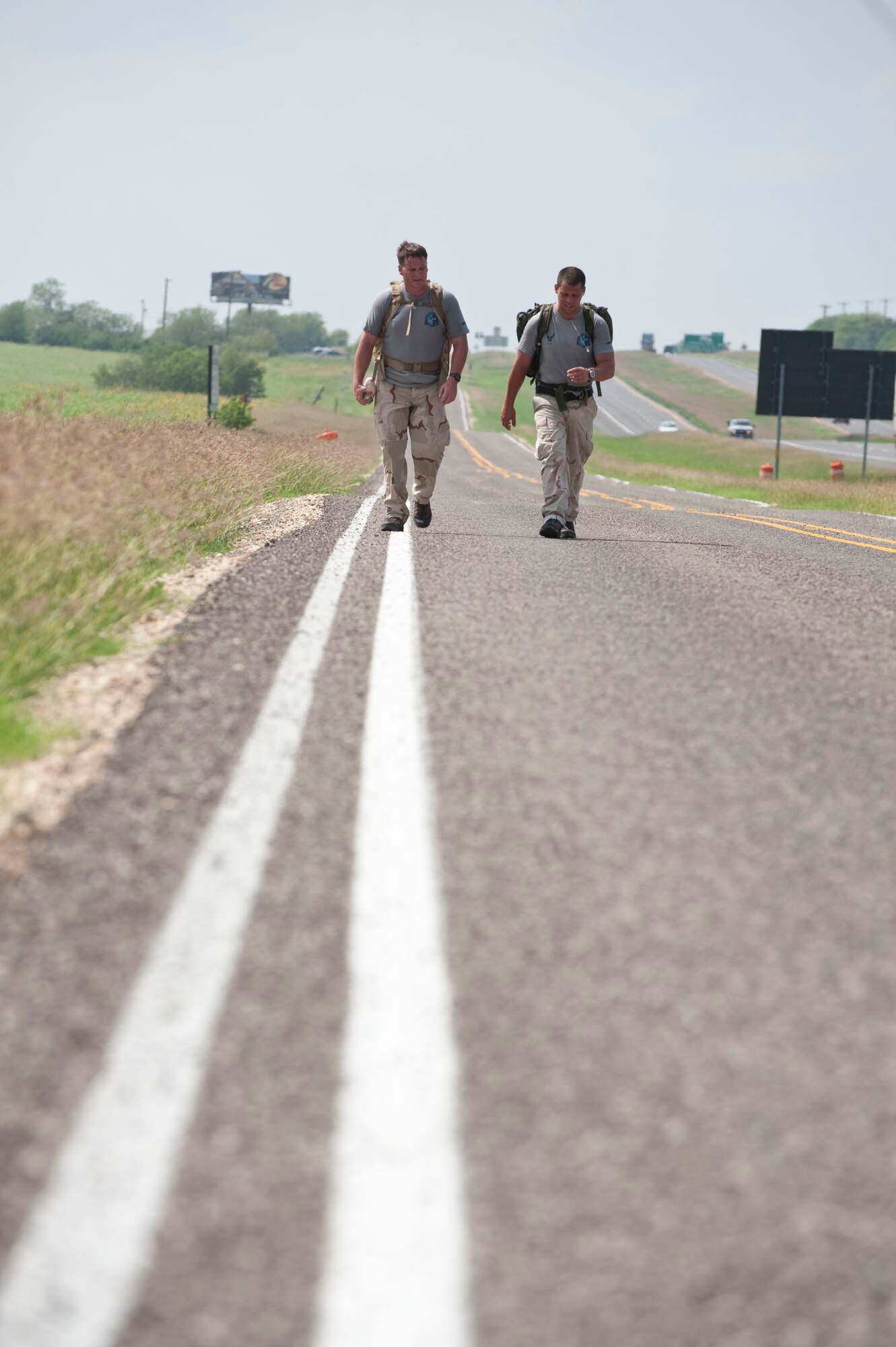 Chief Master Sgt. Tony Travis and Tech. Sgt. Chris Grove, combat controllers with the 23rd Special Tactics Squadron at Hurlburt Field, Fla., walk along I-10 in Texas near mile marker 587 Oct. 6.  The Airmen are participating in the the Special Tactics Memorial Ruck to raise awareness and support for the Special Operations Warrior Foundation and recognize fallen comrades of wars in Iraq and Afghanistan. Six, two-man teams will complete their mission in 10 days by walking 10-15 mile legs around the clock while carrying a ruck weighing at least 50 pounds, which is traditionally used in all training marches. (U.S. Air Force photo/Steve Thurow) 