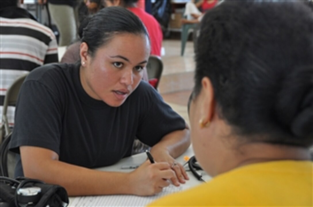 U.S. Air Force Tech. Sgt. Gloria Lafitaga, with the 154th Medical Group, Hawaiian Air National Guard, asks a man about his health concerns during check-in at the Congressional Christian Church of American Samoa in Fagatitua, American Samoa, on Oct. 2, 2009.  A tsunami struck the island Sept. 29 causing wide spread damage.  The Hawaiian Air National Guard is providing basic medical care to residents, some of whom were displaced or lost power in their homes.  The church, with help from the government, is serving three meals a day to those in need.  The Hawaiian Air National Guard treated 158 people.  