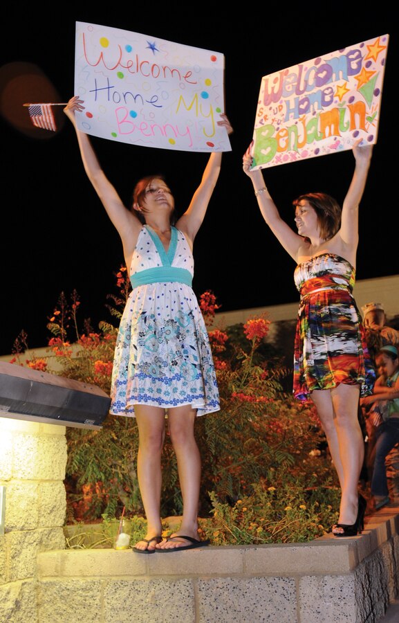 Sam Press, left, and Stacy Press hold signs welcoming home Cpl. Benjamin Press at the Marine Corps Air Station in Yuma, Ariz., Oct. 6, 2009. Press returned with Marine Wing Support Squadron 371's last group of approximately 150 Marines after a seven-month deployment to Afghanistan's Helmand Province. MWSS-371 transferred control of aviation support for Marine Aircraft Group 40 to MWSS-372 from Camp Pendleton, Calif., Sept. 28, 2009. During the deployment, MWSS-371 built the largest expanse of aluminum matting in a combat zone, which was more than 2.2 million square feet. "I can't express how proud I am of these Marines," said Sgt. Maj. John Scott, MWSS-371's sergeant major, who also returned with the last group. "They didn't meet expectations, they exceeded them. It was an incredible deployment."