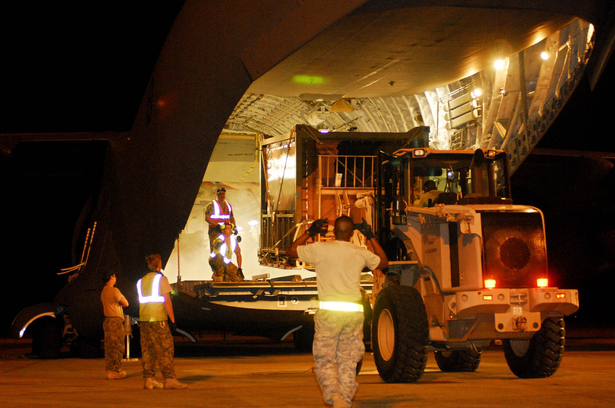 U.S. Airmen help unload a Royal Australian Air Force C-17 Globemaster III Oct. 6 in Padang, Indonesia.  The aircraft brought an Australian Army water purification and civil engineering team to Indonesia to assist in the ongoing relief efforts.  Sixty-nine U.S. Airmen are in Padang as part of the deployment of the U.S. Air Force Humanitarian Assistance Rapid Response Team. (Australian Department of Defence photo/CPL Guy Young)