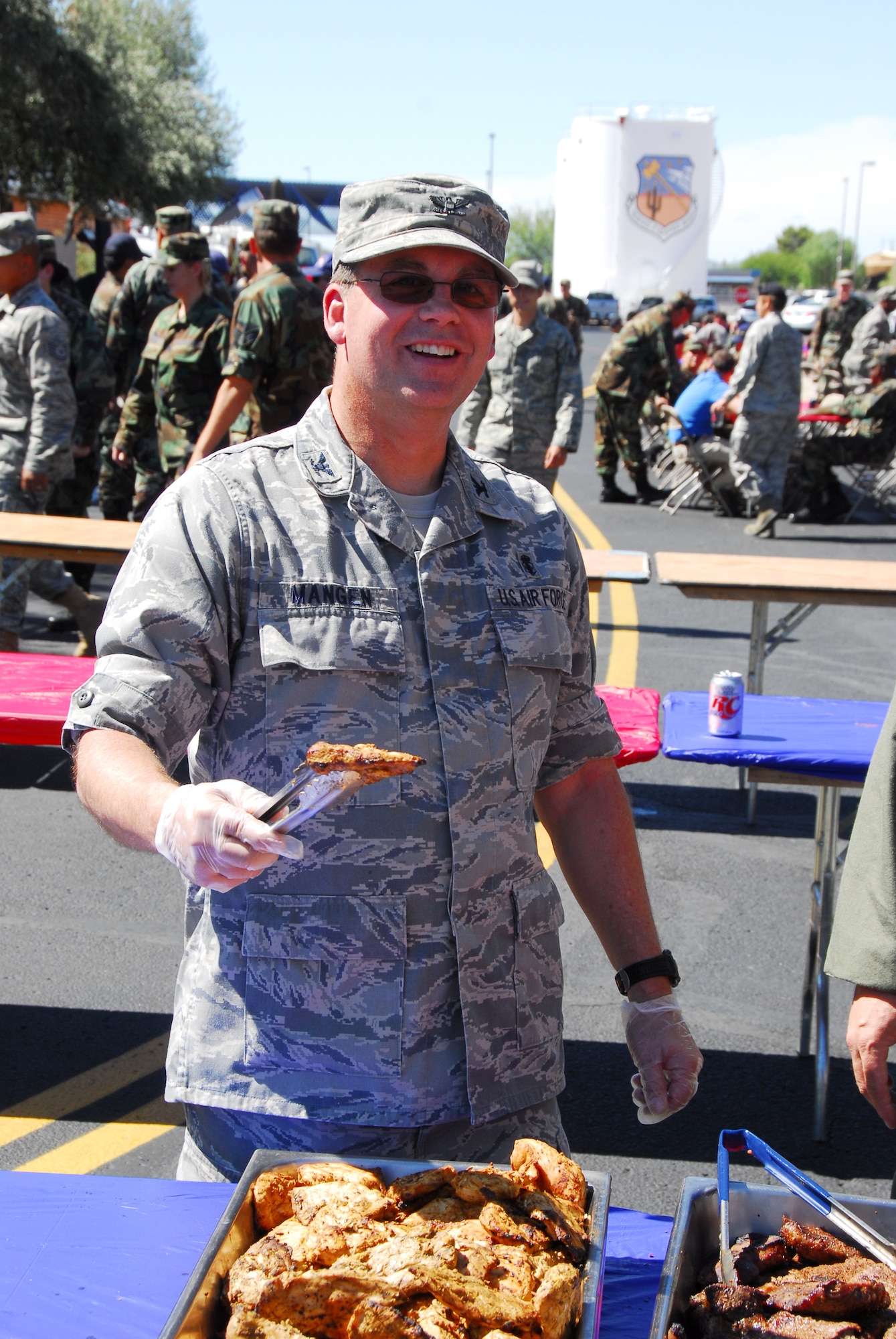 Col. Michael Mangen serves up chicken at the annual Steak Fry. The lunch was sponsored by 162nd Fighter Wing and 214th Reconnaissance Group officers and senior NCOs for junior enlisted members who always eat free at the event. (Air National Guard photo Master Sgt. Dave Neve)